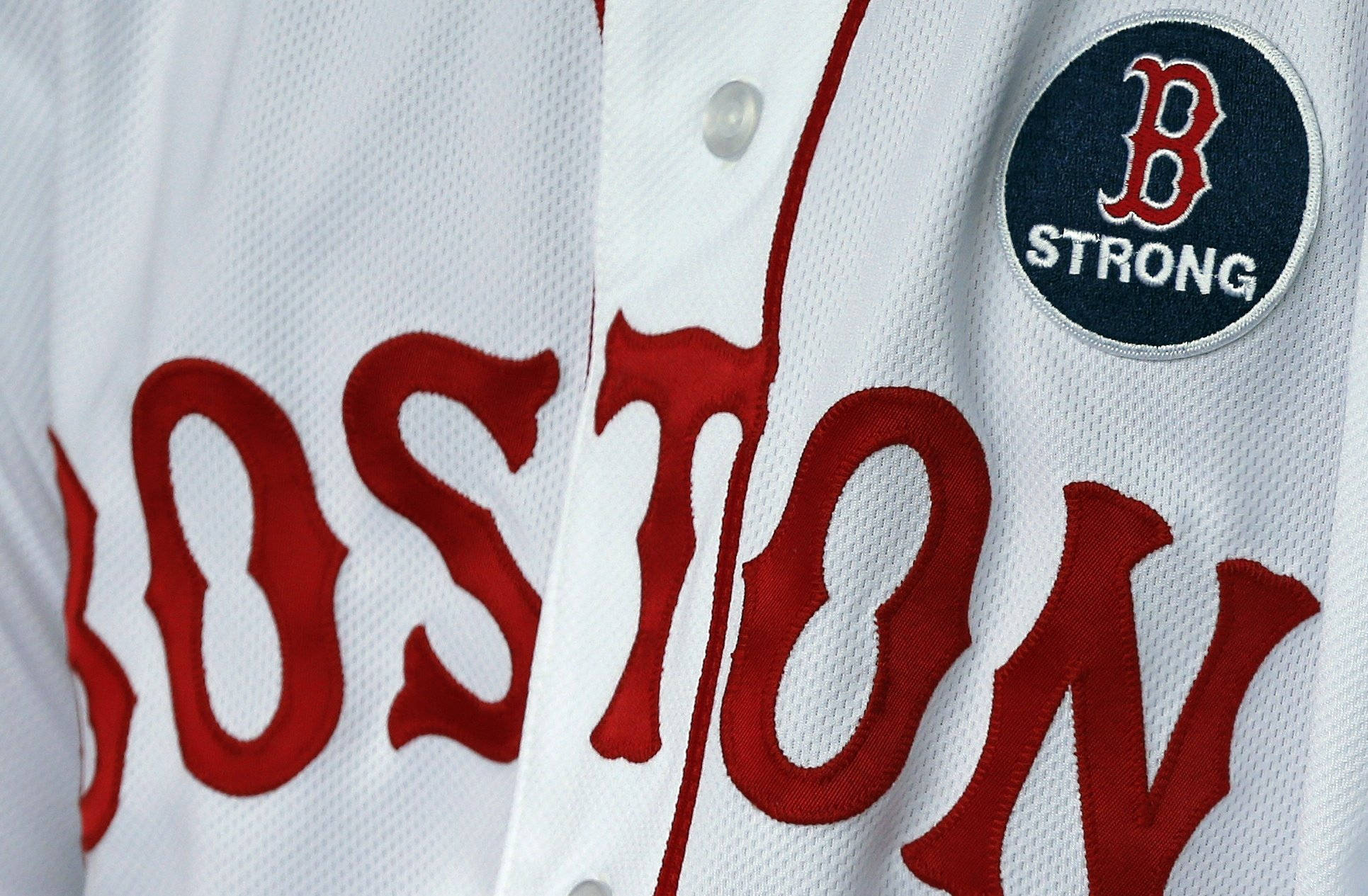 Boston Red Sox 桌布 壁紙 — 白色棒球衫特寫，帶有粗體紅色 'BOSTON' 字樣和 'B STRONG' 補丁。