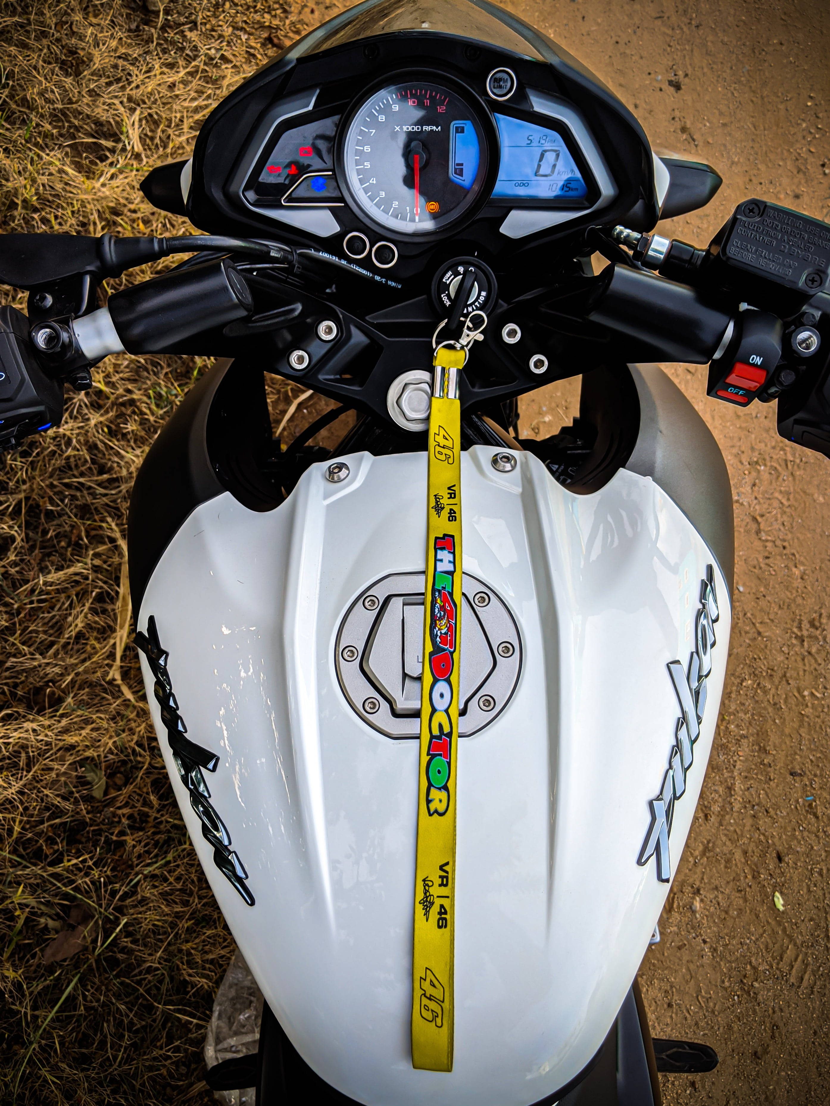 機車 桌布 壁紙 — 白色機車的油箱和把手特寫，黃色VR46鑰匙圈掛在點火開關上。