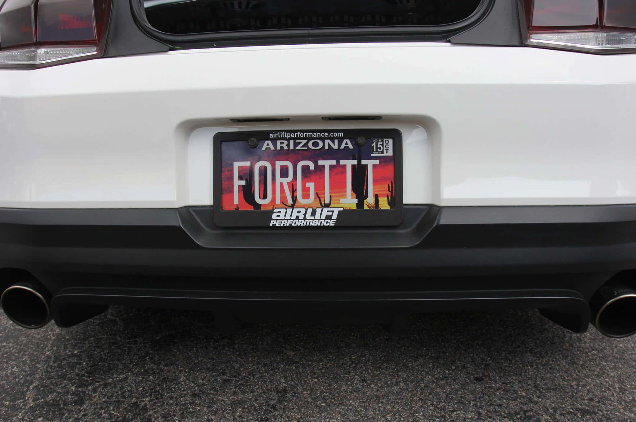 Car License Plate 桌布 壁紙 — 白色汽車後保險桿的特寫，顯示亞利桑那州車牌，上面有「FORGTIT」和沙漠日落設計。