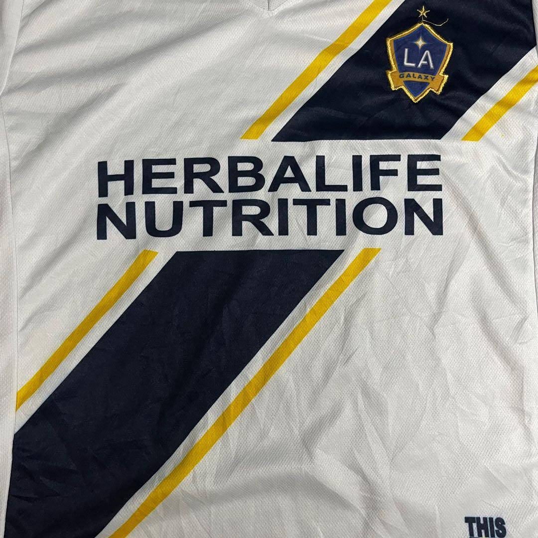 足球 桌布 壁紙 — 白色洛杉磯銀河足球球衣近照，帶有Herbalife Nutrition贊助及海軍藍黃色斜紋。