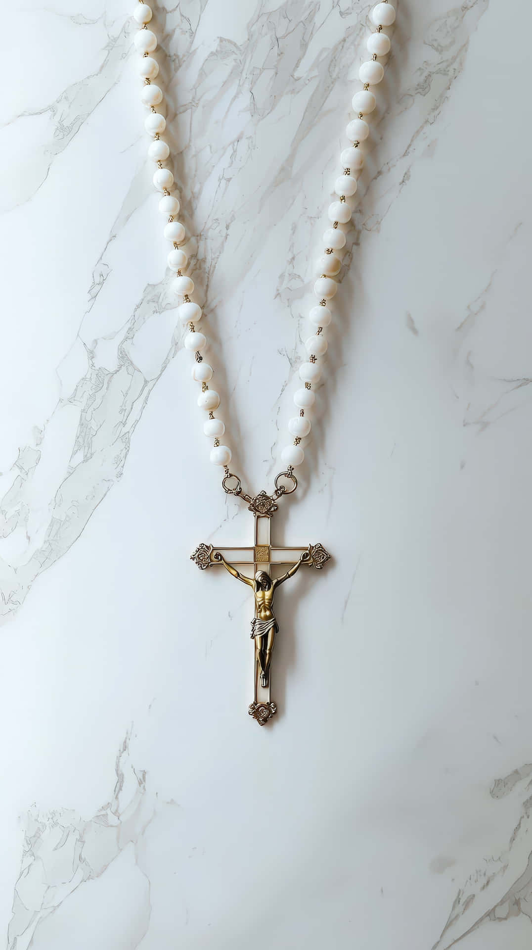 A Catholic rosary with white beads and a golden crucifix featuring Jesus Christ 壁紙 — 白色珍珠玫瑰經與金色十字架優雅地放置在拋光大理石表面上。