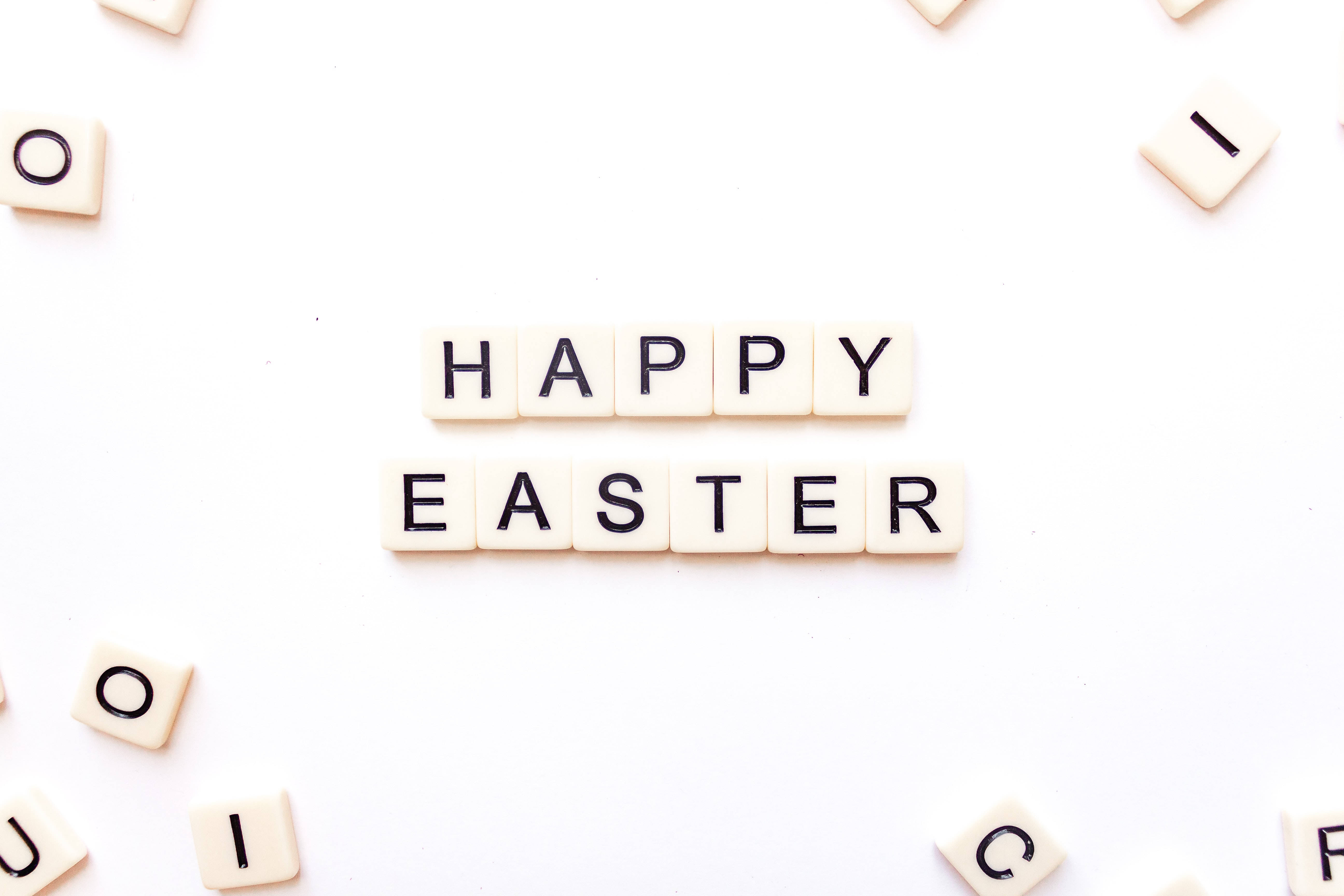 Happy Easter 桌布 壁紙 — 白色瓷磚在明亮的白色背景中央拼出「HAPPY EASTER」，周圍散落著字母瓷磚。