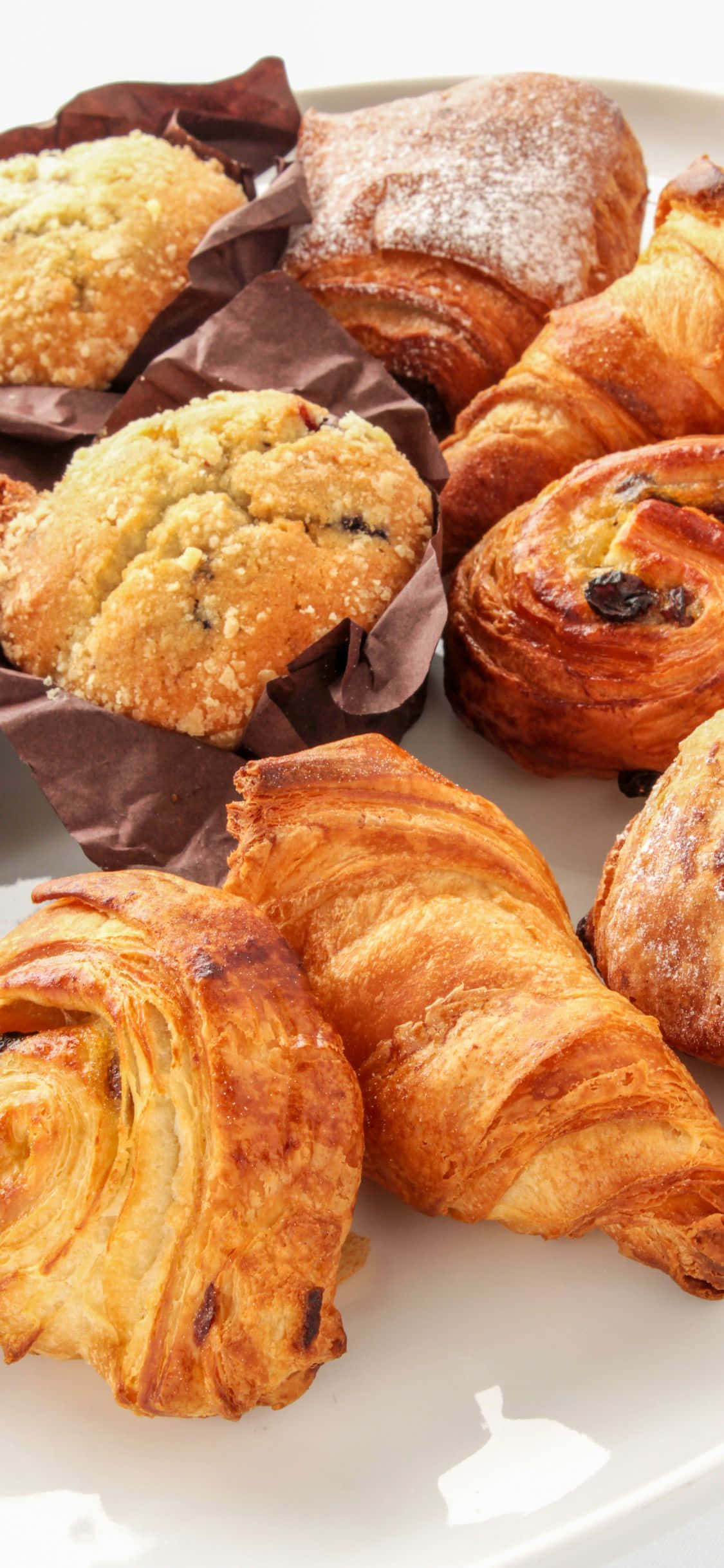 Croissant 桌布 壁紙 — 白色盤子上灑滿糖霜的金黃酥脆可頌和馬芬的特寫。