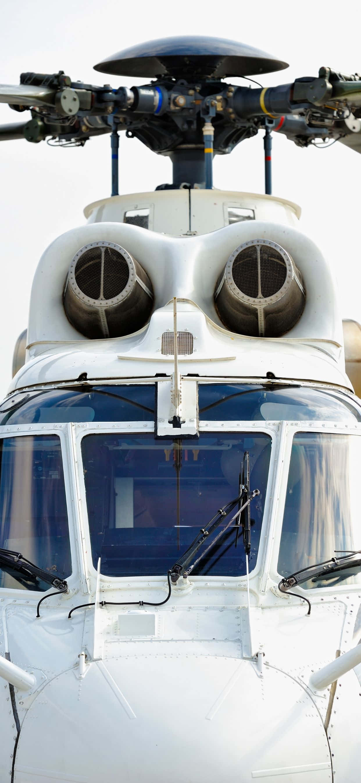 iPhone Xs Max Helicopters 桌布 壁紙 — 白色直升機的駕駛艙和雙引擎在明亮天空下的特寫。