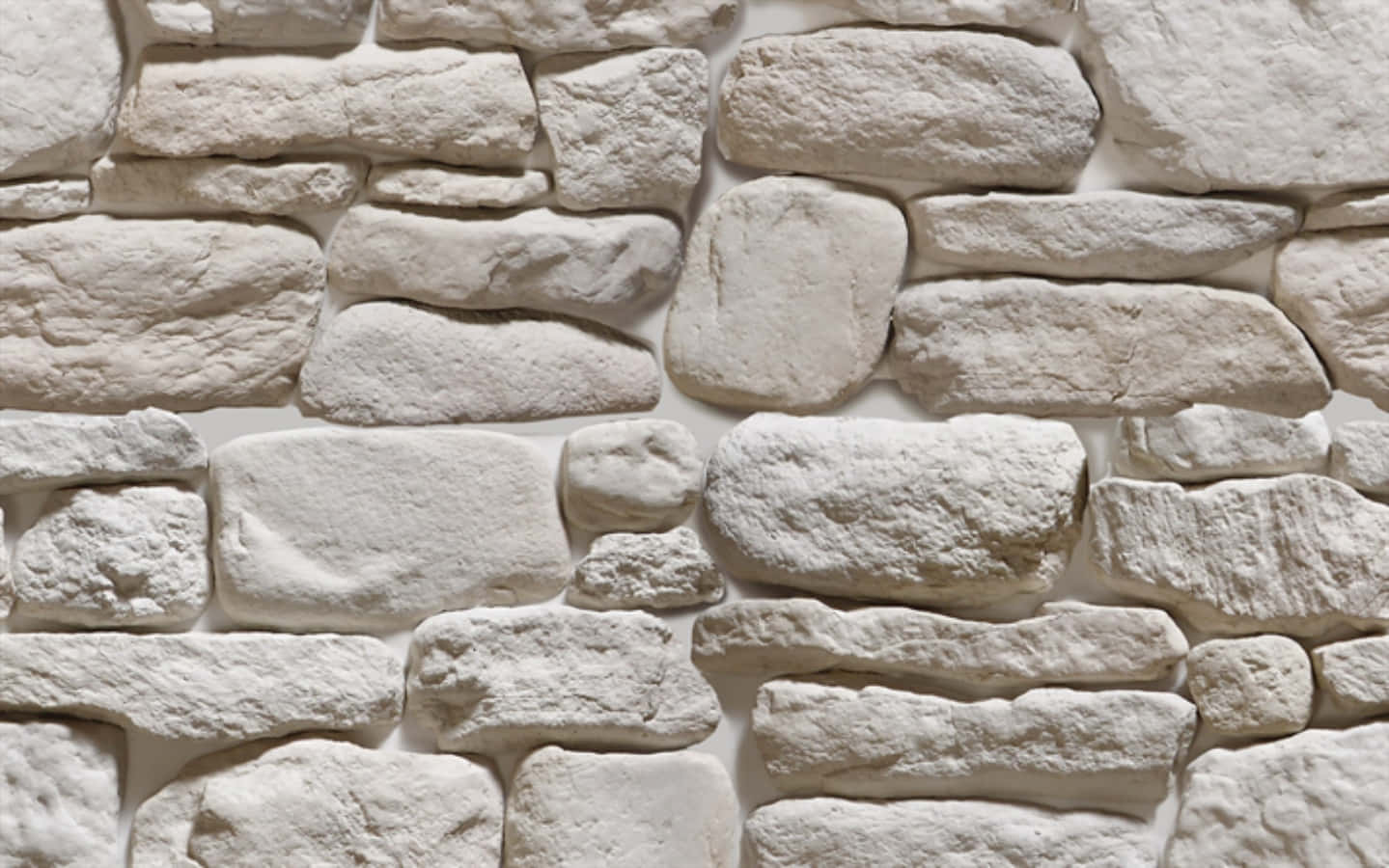 Stone Wall 桌布 壁紙 — 白色石牆特寫，紋理清晰，石塊形狀不規則，帶有柔和陰影。