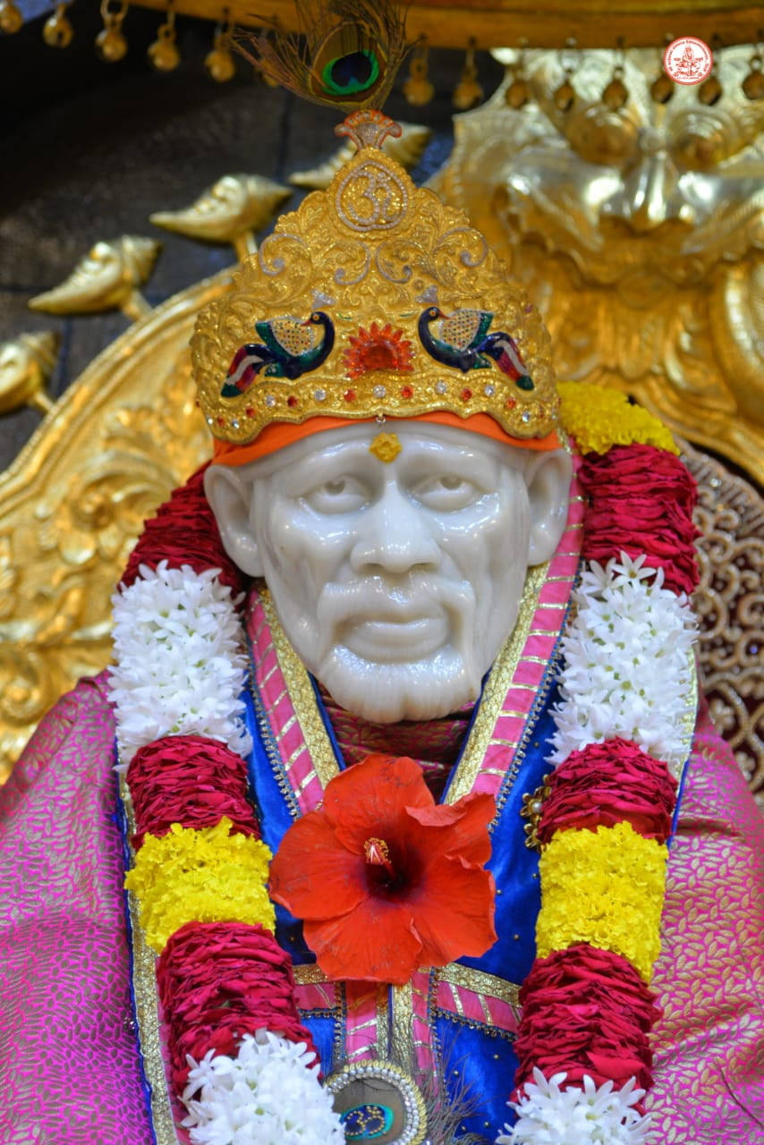 白色石神像，戴著金色皇冠和彩色花環。 — Sai Baba 高畫質壁紙 壁紙
