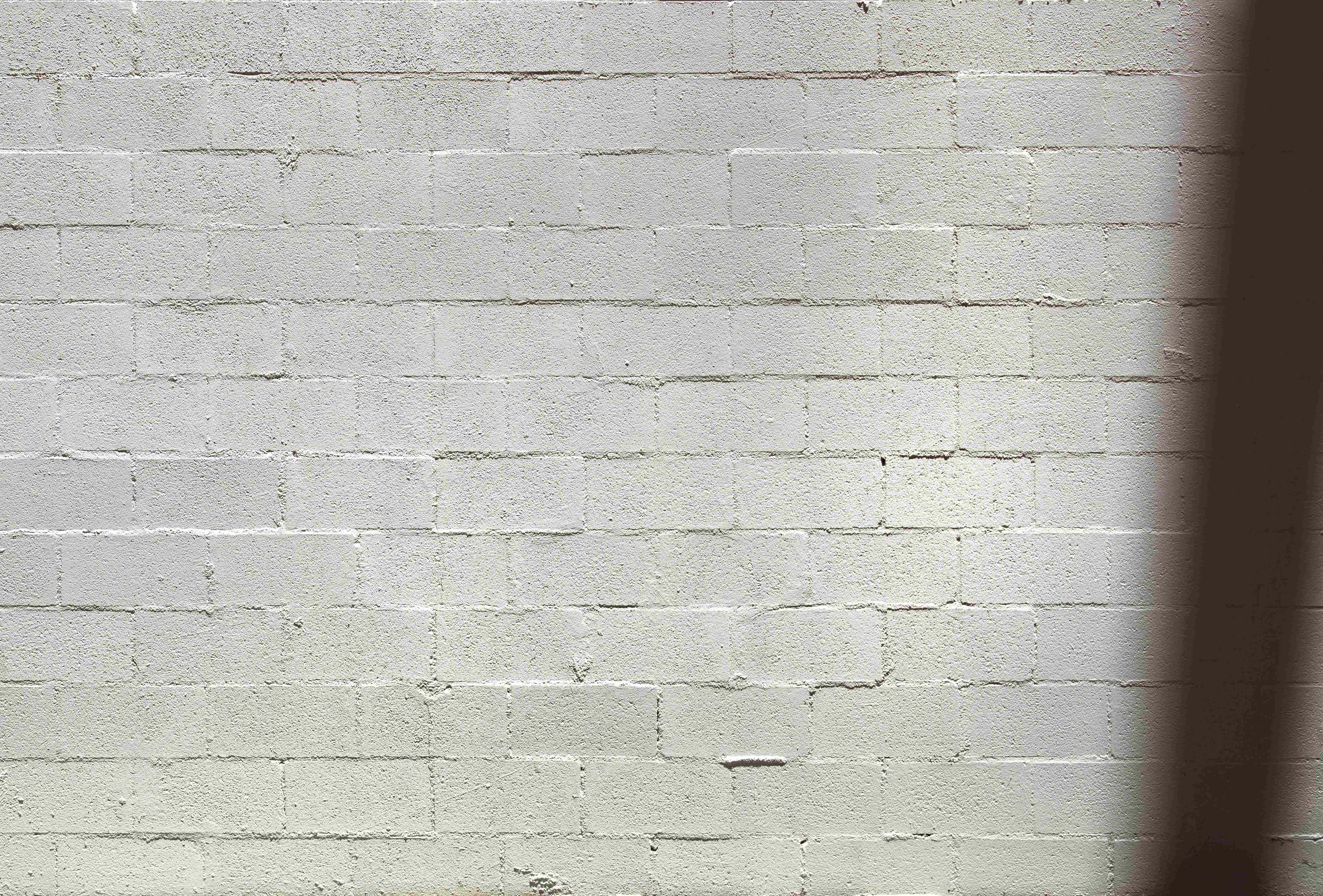 White Brick Wall 桌布 壁紙 — 白色磚牆的特寫，帶有附近物體投射的柔和陰影。