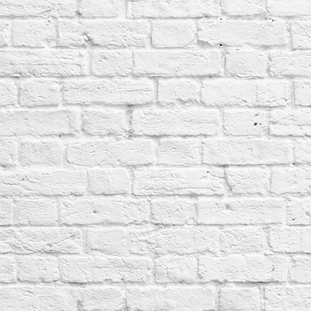 White Brick 桌布 壁紙 — 白色磚牆的特寫，顯示出有紋理的砂漿和細微的瑕疵。