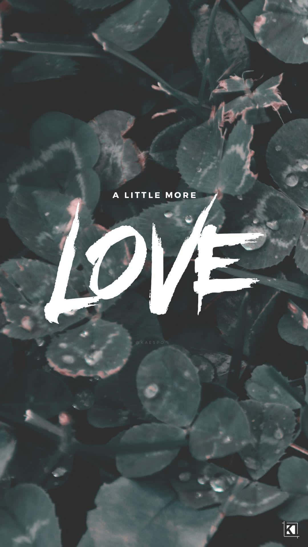 mgk 桌布 壁紙 — 白色筆觸文字寫著「LOVE」和「A LITTLE MORE」，覆蓋在帶露水的深綠色三葉草葉片上，營造出陰鬱的特寫效果。