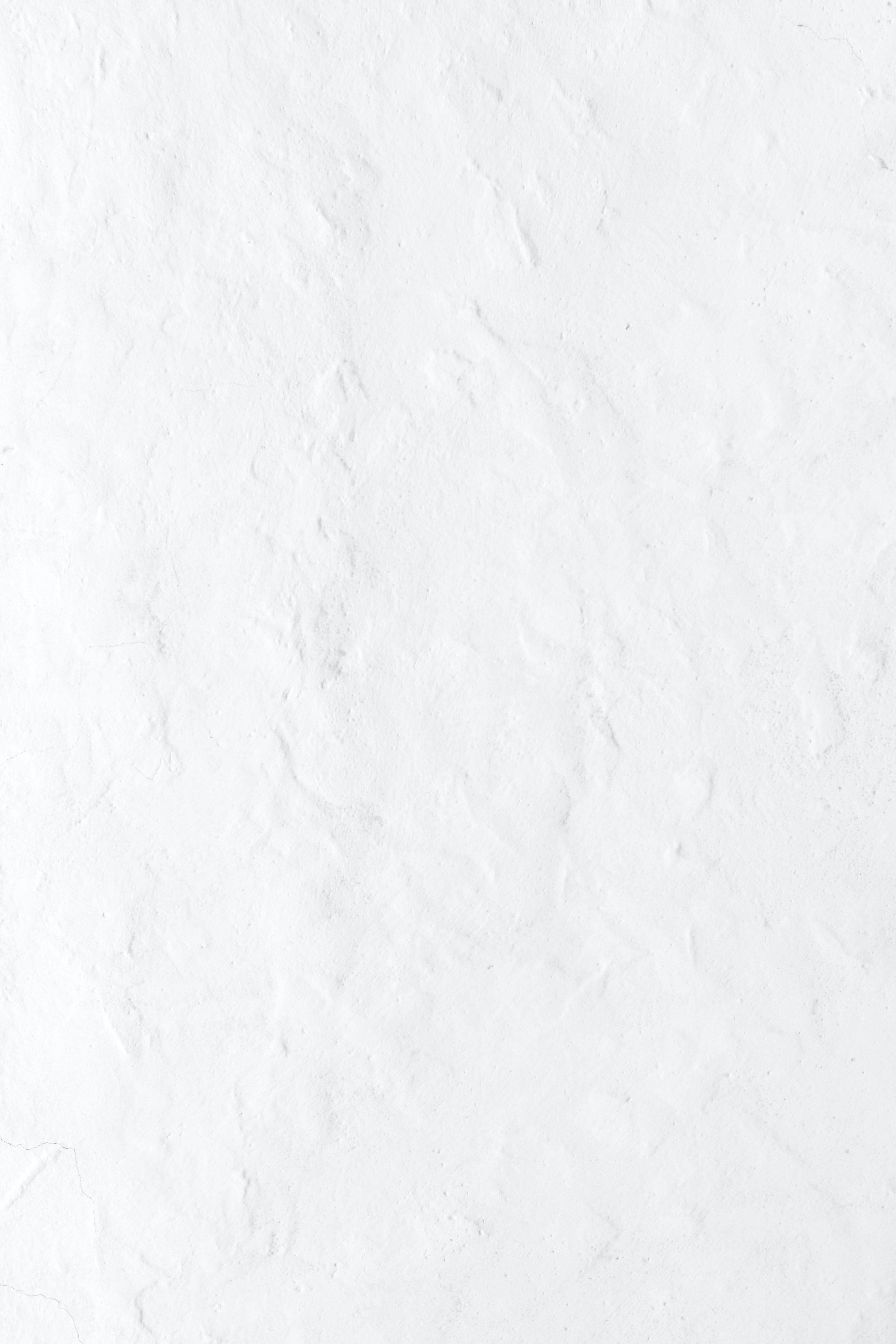 Pure White 桌布 壁紙 — 白色紋理灰泥牆的特寫，帶有細微裂縫和不均勻的表面細節。
