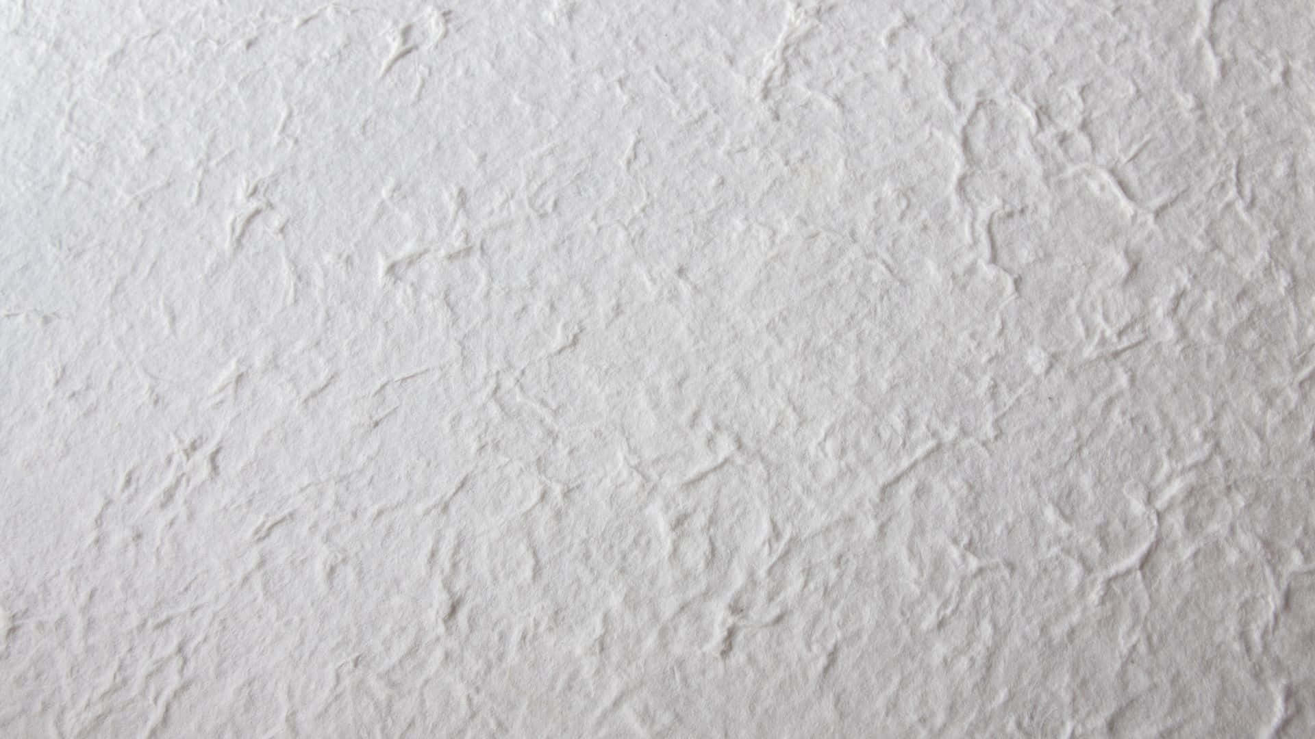 Textured 桌布 壁紙 — 白色紋理牆壁的特寫，帶有微妙的壓花圖案和柔和陰影。