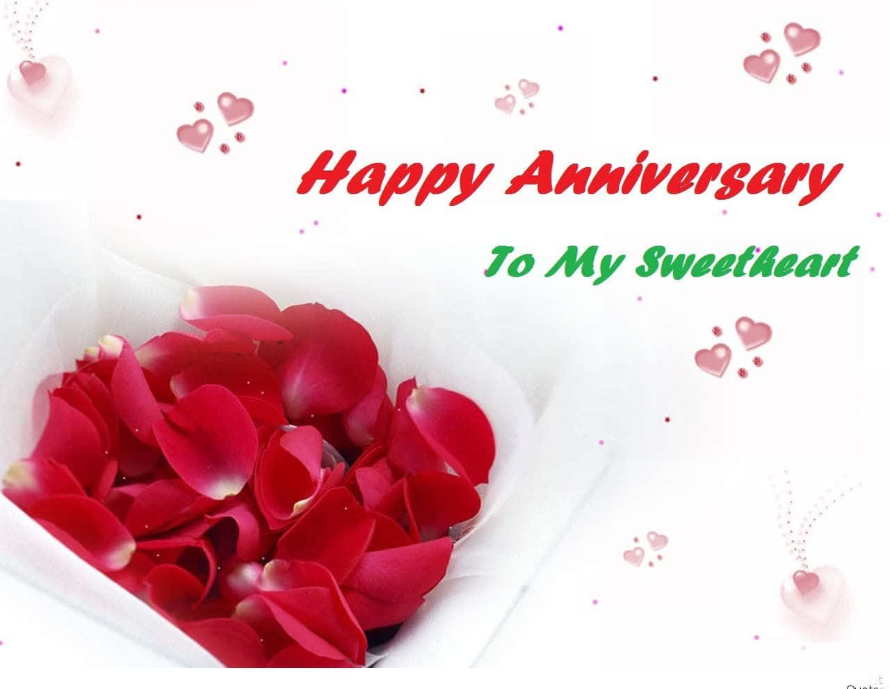 Anniversary 桌布 壁紙 — 白色紙上以鮮紅色玫瑰花瓣排列成心形，並帶有「Happy Anniversary To My Sweetheart」文字和漂浮的粉紅色心形。