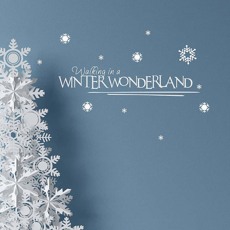 Christmas Winter Wonderland 桌布 壁紙 — 白色紙雪花和文字點綴柔軟的藍色紋理牆壁，營造出舒適的冬季仙境氛圍。