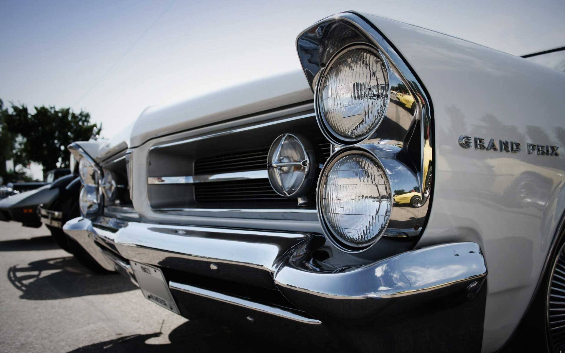 Pontiac 桌布 壁紙 — 白色經典車閃亮鍍鉻格柵和圓形頭燈在明亮日光下的特寫。