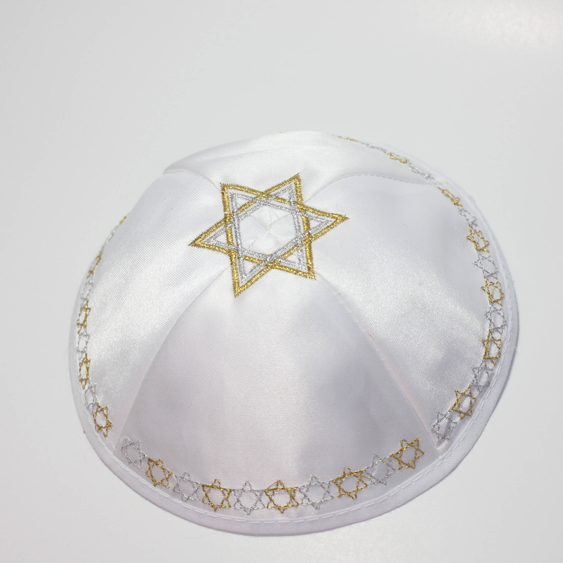 Yom Kippur 桌布 壁紙 — 白色緞面圓頂小帽，素色背景上飾有金銀刺繡的大衛之星圖案。