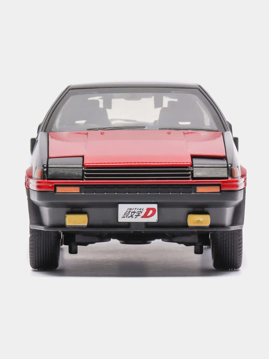 頭文字D 桌布 壁紙 — 白色背景上，一輛帶有「Initial D」車牌的紅黑色玩具跑車的背面視圖。