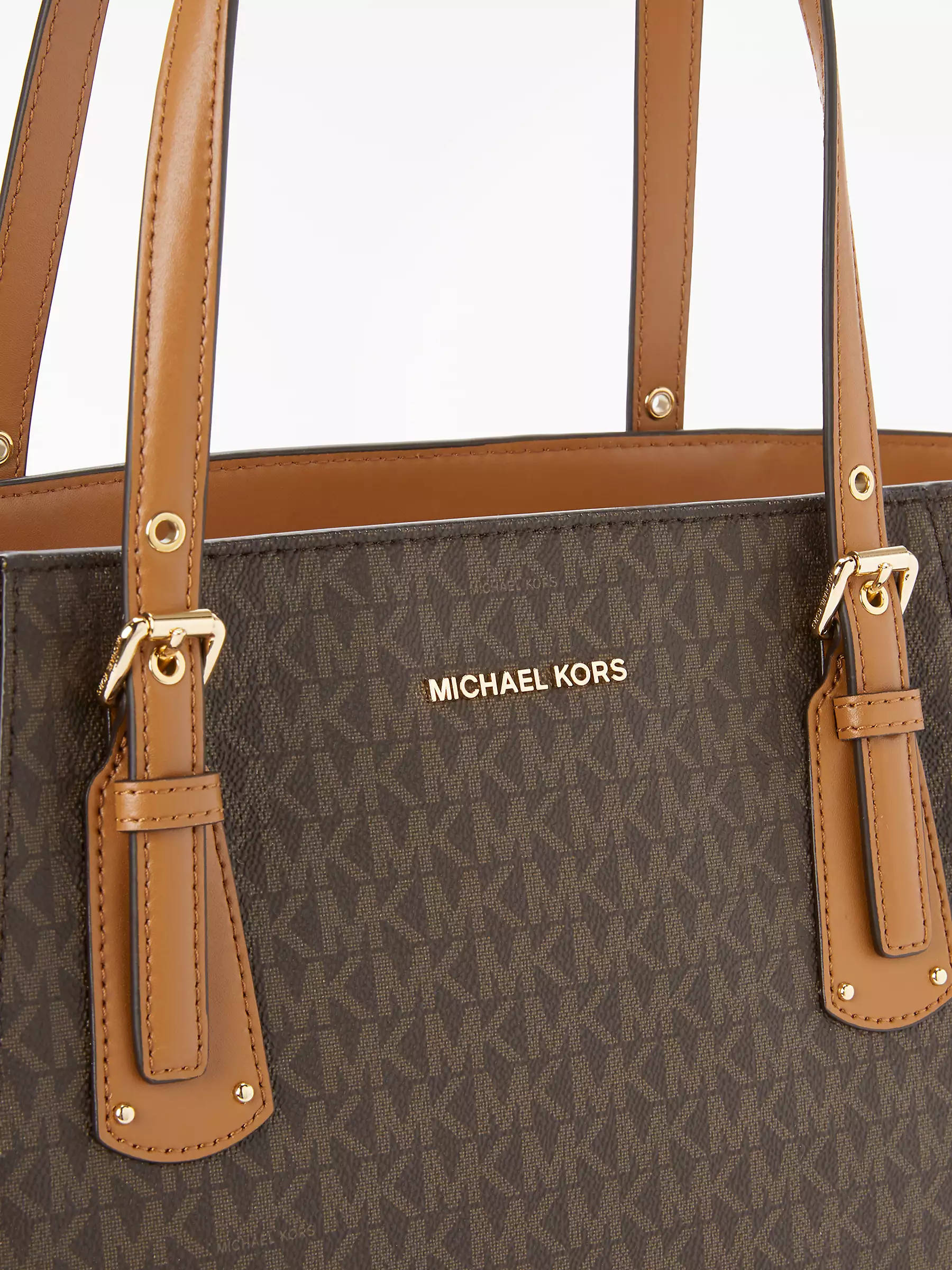 michael 桌布 壁紙 — 白色背景上，棕色Michael Kors托特包、棕褐色皮革肩帶和金色金屬配件的特寫。