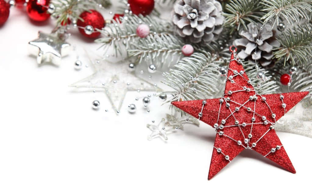Christmas Star 桌布 壁紙 — 白色背景上，雪花覆蓋的冷杉枝條上擺放著紅色閃粉星星、銀色松果和裝飾品的節日特寫。