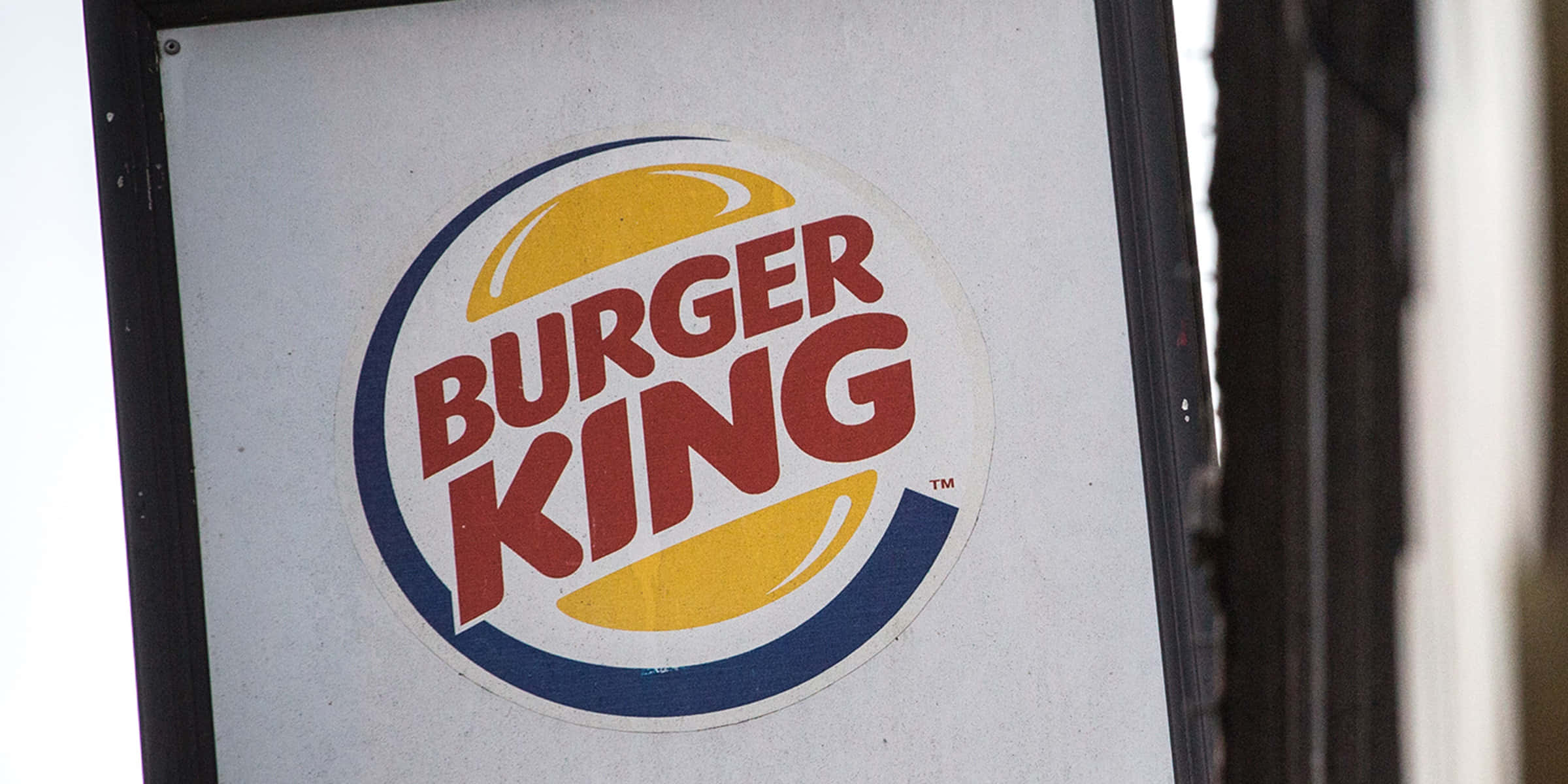 漢堡王 桌布 壁紙 — 白色背景上帶有紅色、黃色和藍色的風化Burger King標誌招牌的特寫。