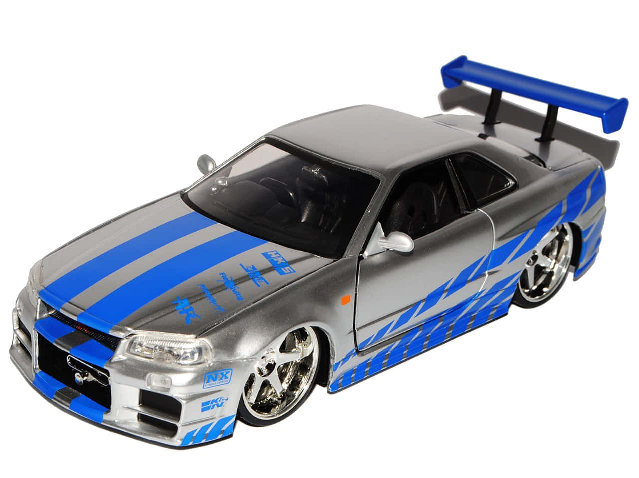 Paul Walker Skyline 桌布 壁紙 — 白色背景上帶有賽車條紋和大尾翼的銀藍色壓鑄日產Skyline R34。