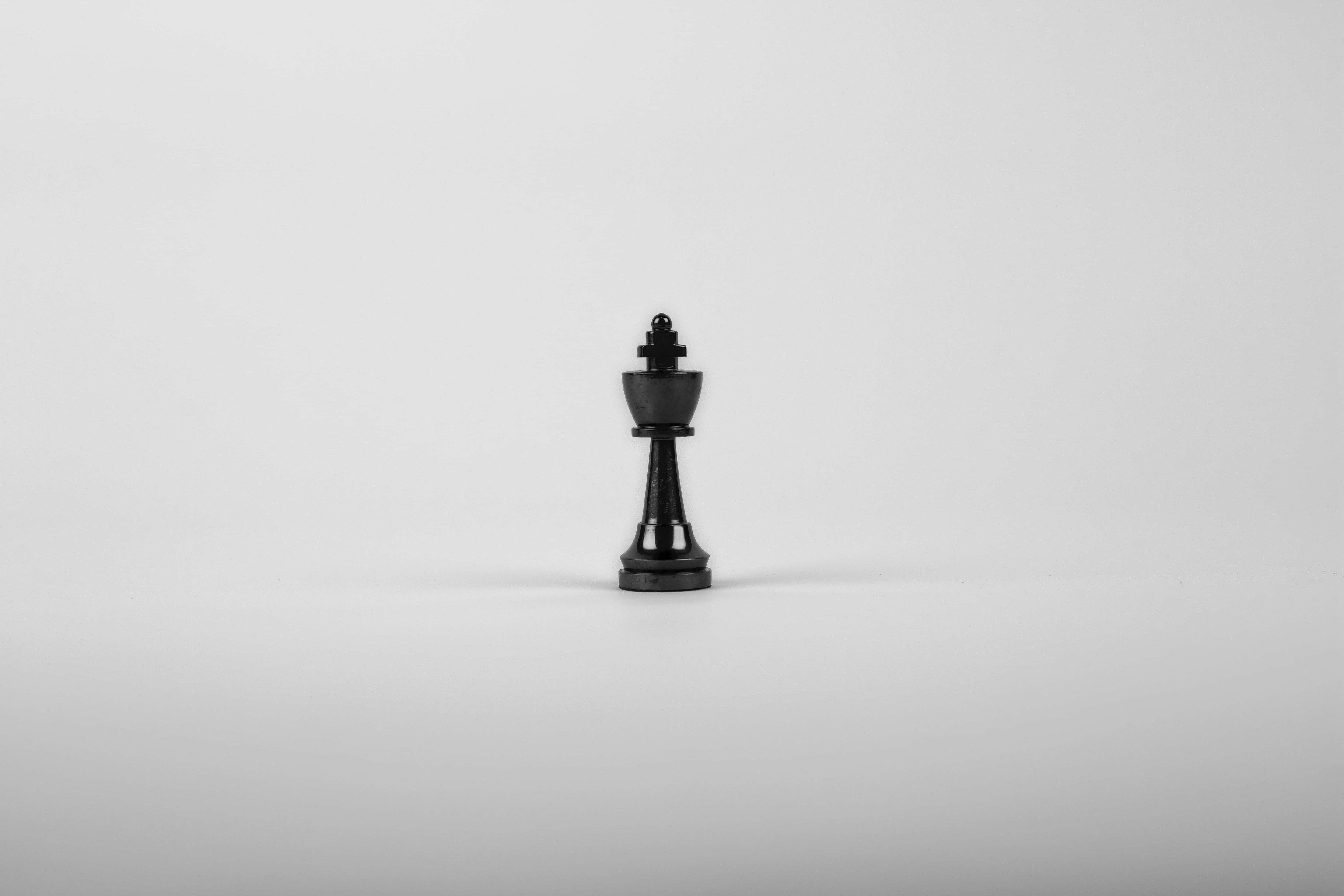 白色背景上的一枚黑色西洋棋棋子 壁紙