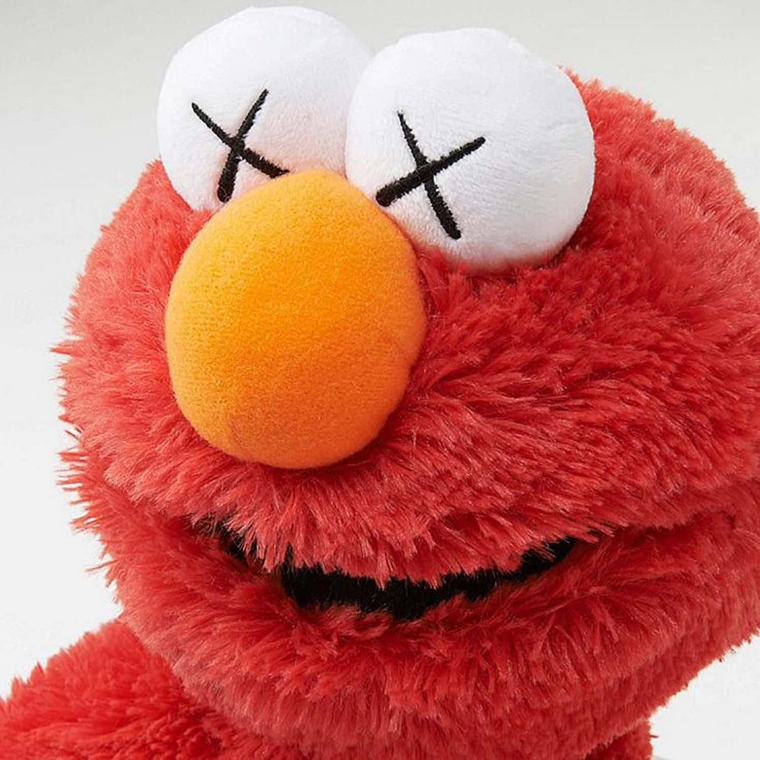 Kaws Sesame Street 桌布 壁紙 — 白色背景前，紅色毛絨Elmo玩偶的特寫，眼睛以X形縫製，鼻子為橙色。
