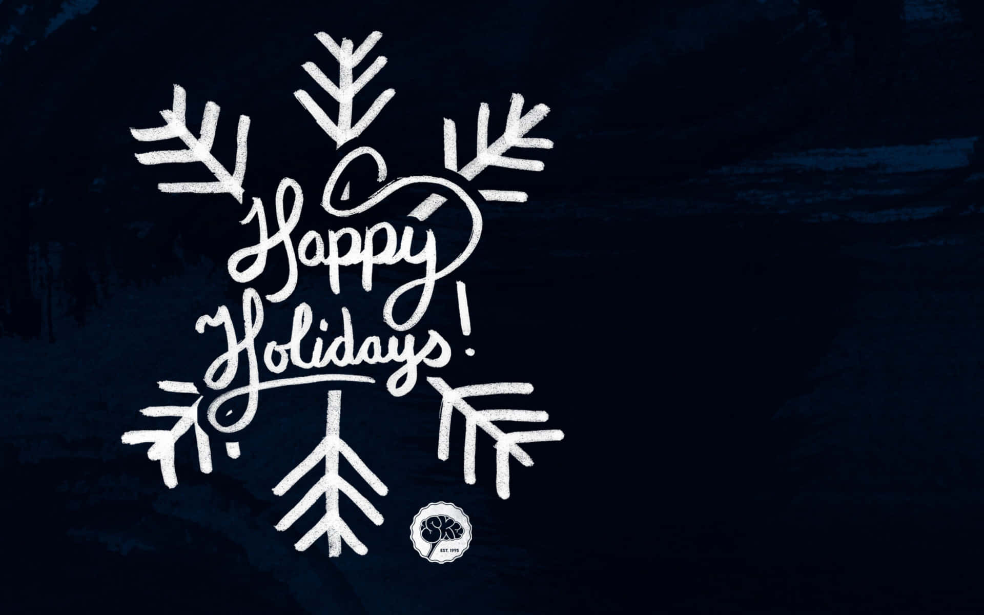 桌布 壁紙 — 白色草書 'Happy Holidays!' 文字嵌在雪花設計中，背景為有紋理的深藍色。