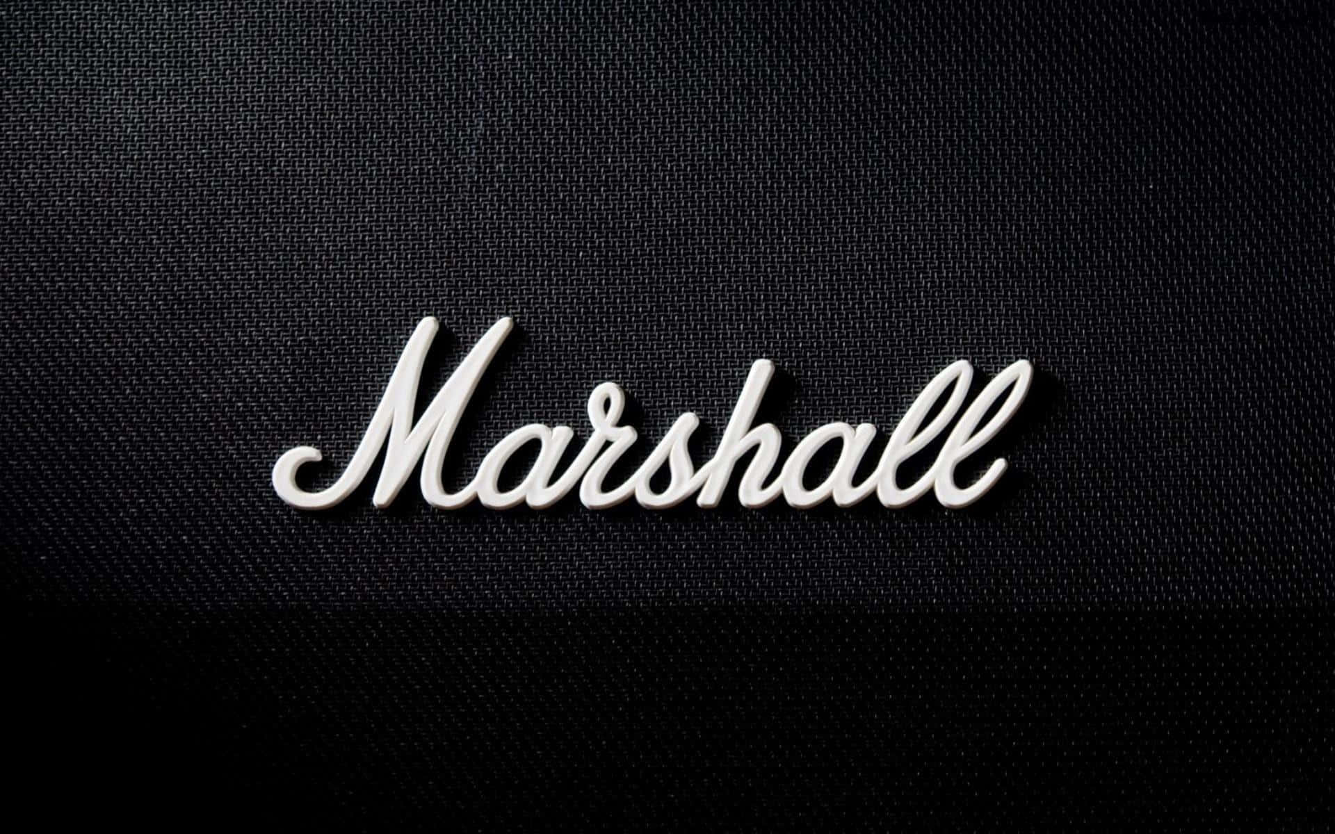 Marshall 桌布 壁紙 — 白色草書Marshall標誌刺繡在帶有紋理的黑色布料上，光線柔和。