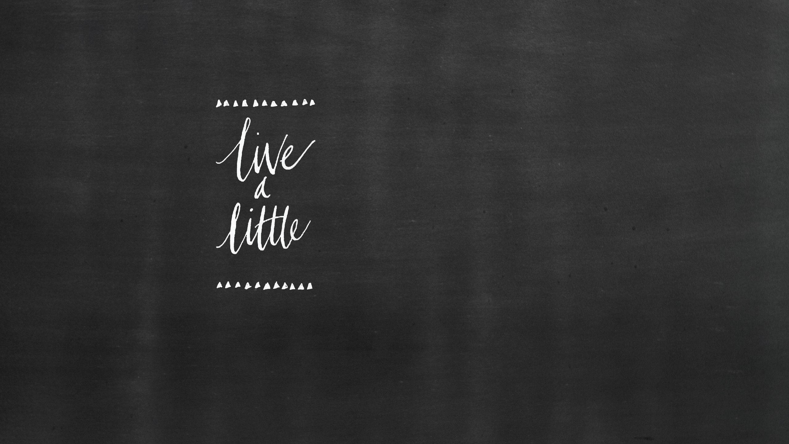 Chalkboard 桌布 壁紙 — 白色草書文字「live a little」居中顯示在帶有紋理的深灰色黑板背景上。