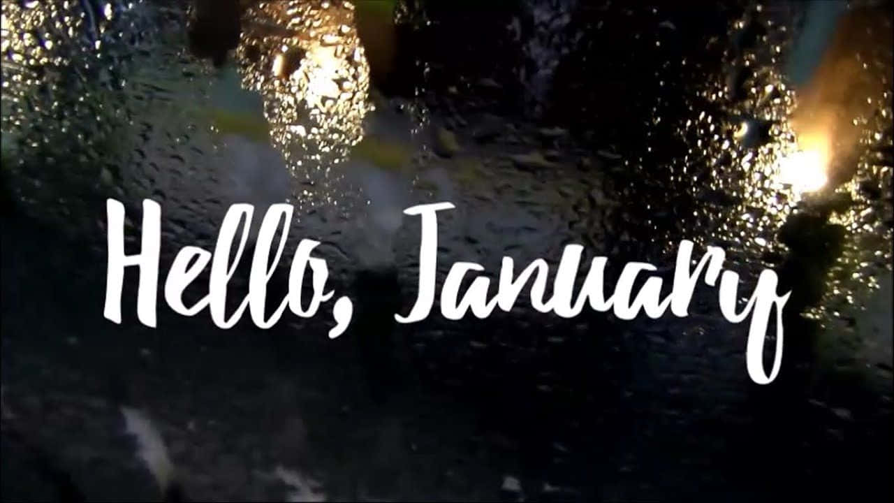 Hello January 桌布 壁紙 — 白色草書文字寫著你好一月，背景是黑暗的雨窗，模糊的街燈反射在水滴上。