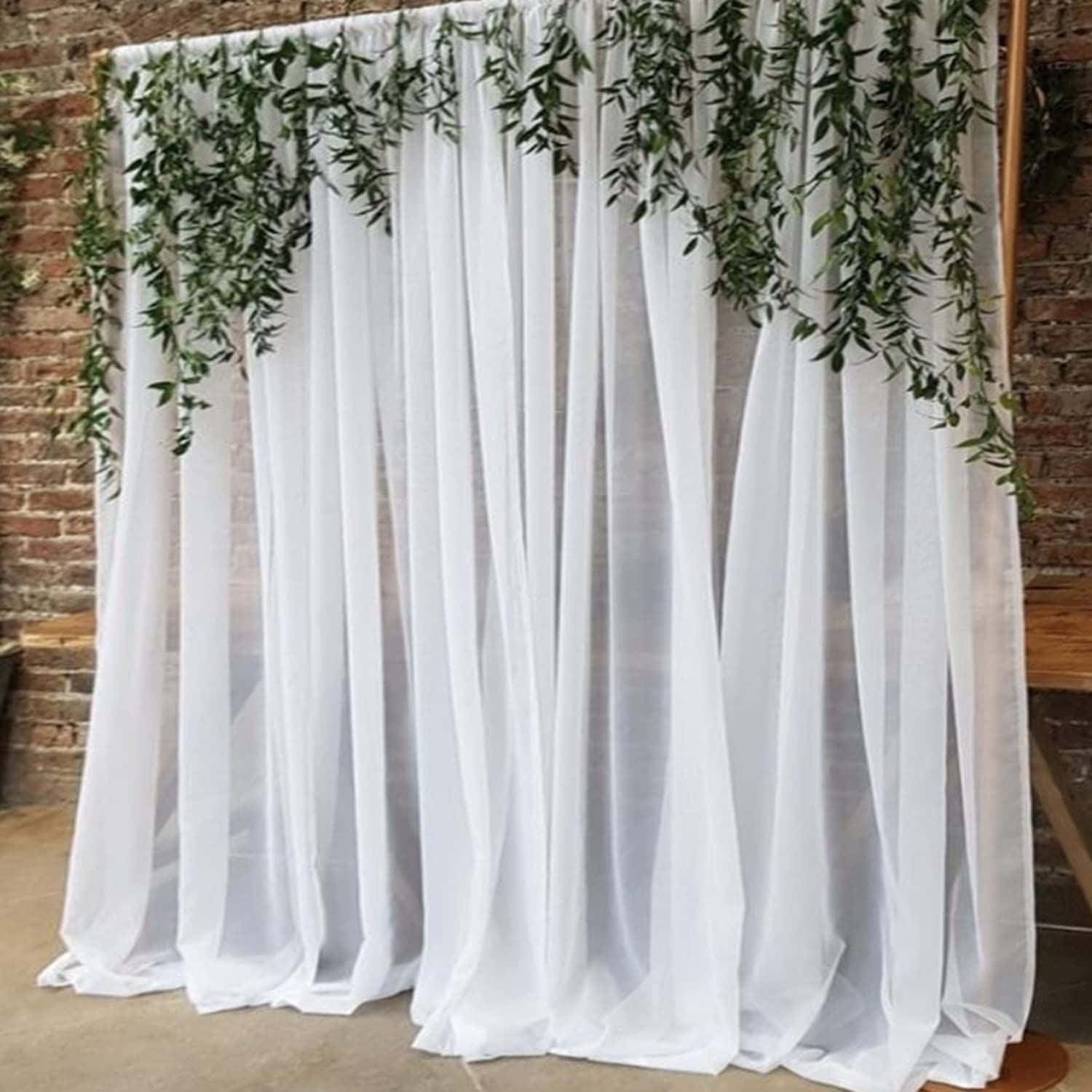 Wedding 桌布 壁紙 — 白色薄紗窗簾披在磚牆上，頂部有綠色藤蔓垂落。