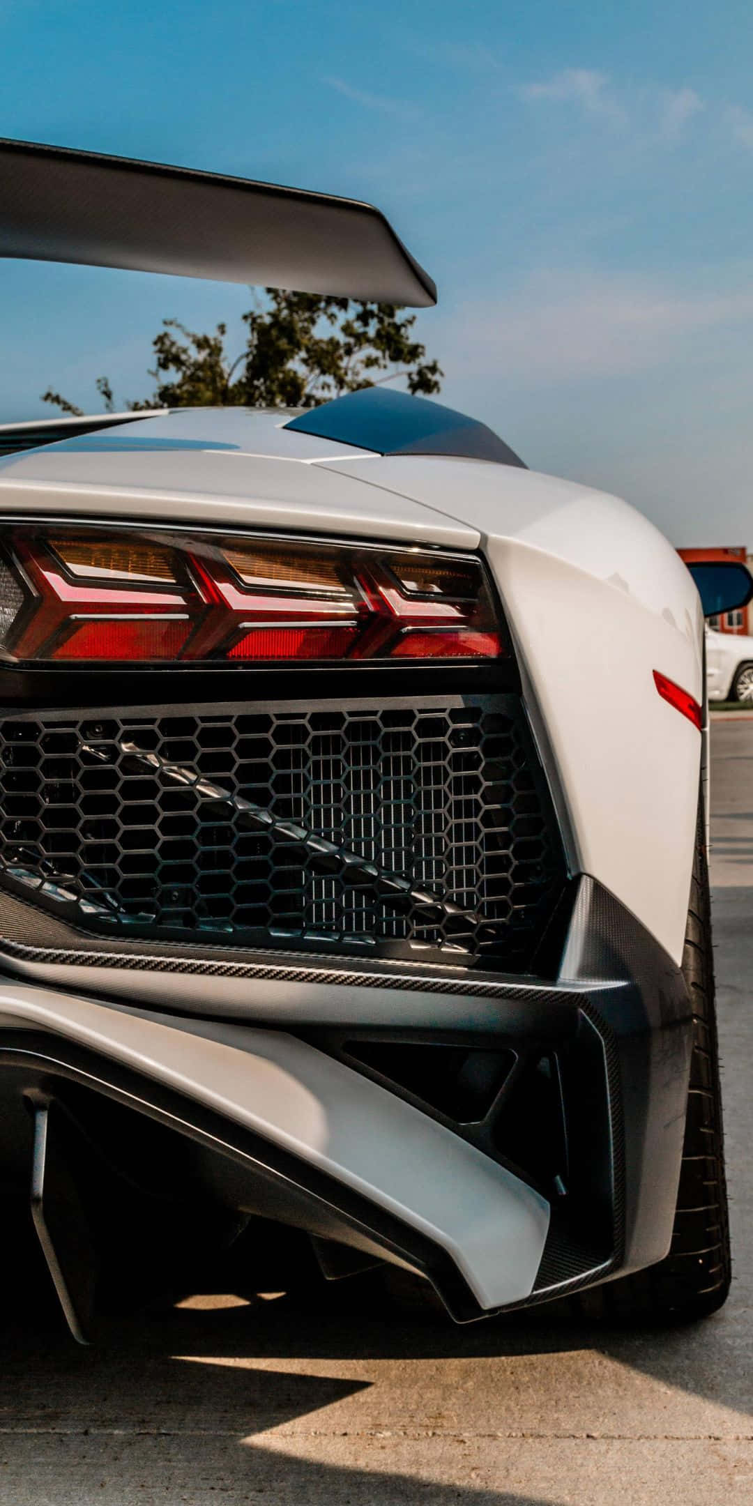Pixel 3 Lamborghini 桌布 壁紙 — 白色藍寶堅尼車尾特寫，在晴朗藍天下展示其進取設計和發光的紅色尾燈。