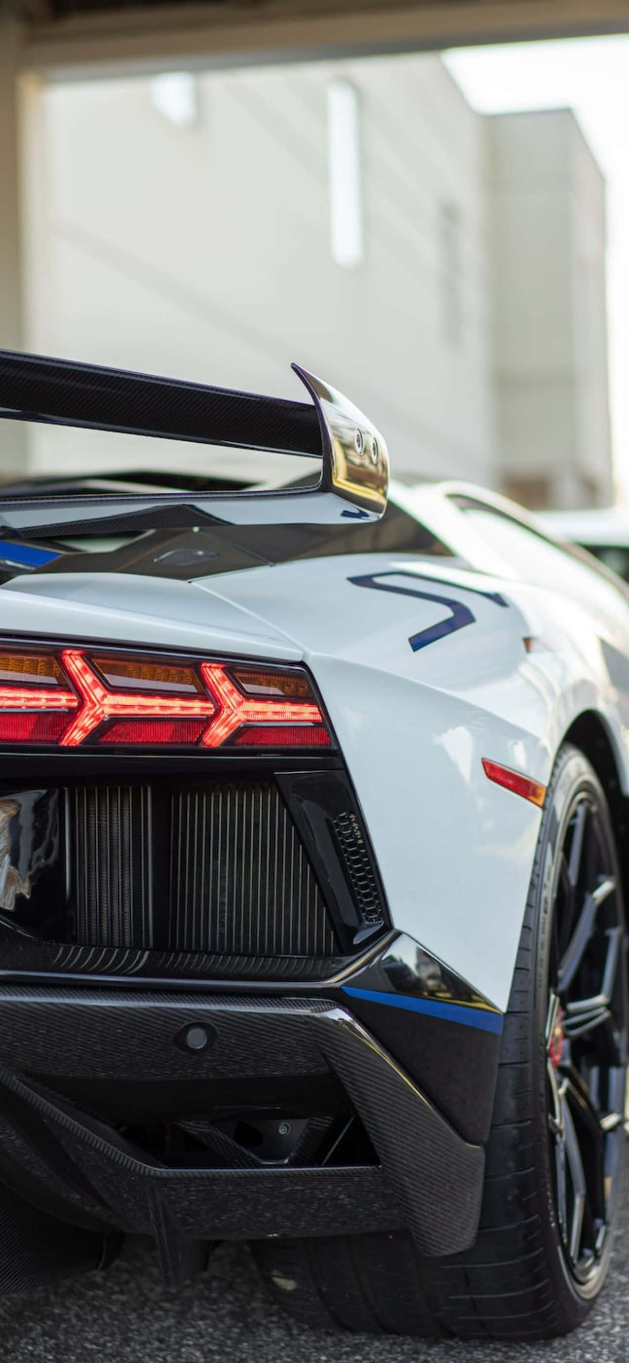 Lamborghini Phone 桌布 壁紙 — 白色藍寶堅尼車尾特寫，展示發光的紅色尾燈和碳纖維細節。