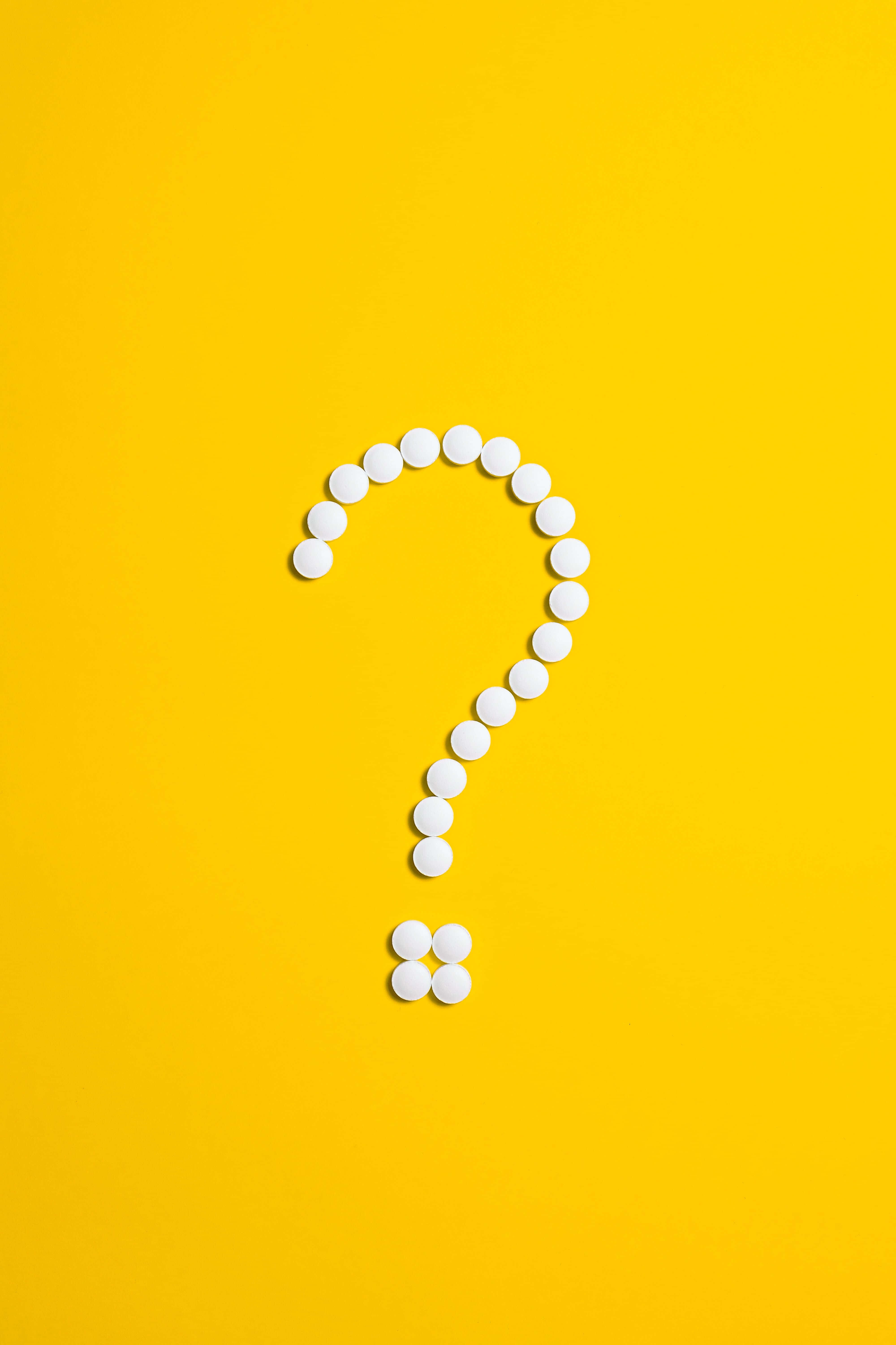 Question Mark 桌布 壁紙 — 白色藥丸在鮮黃色背景上排列成問號形狀。