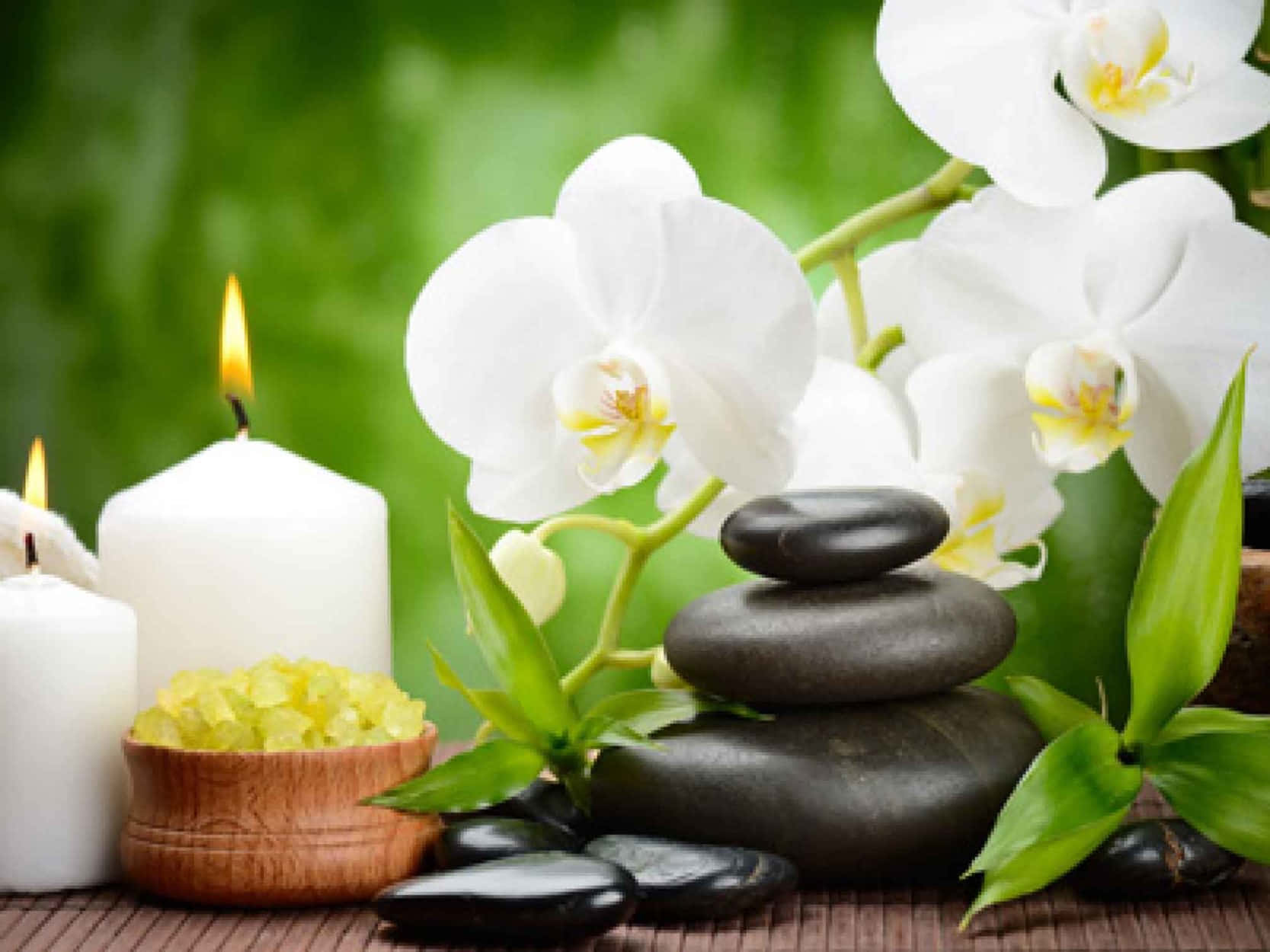 禪 桌布 壁紙 — 白色蘭花、黑色石頭和點燃的蠟燭在竹蓆上營造出寧靜的水療氛圍。