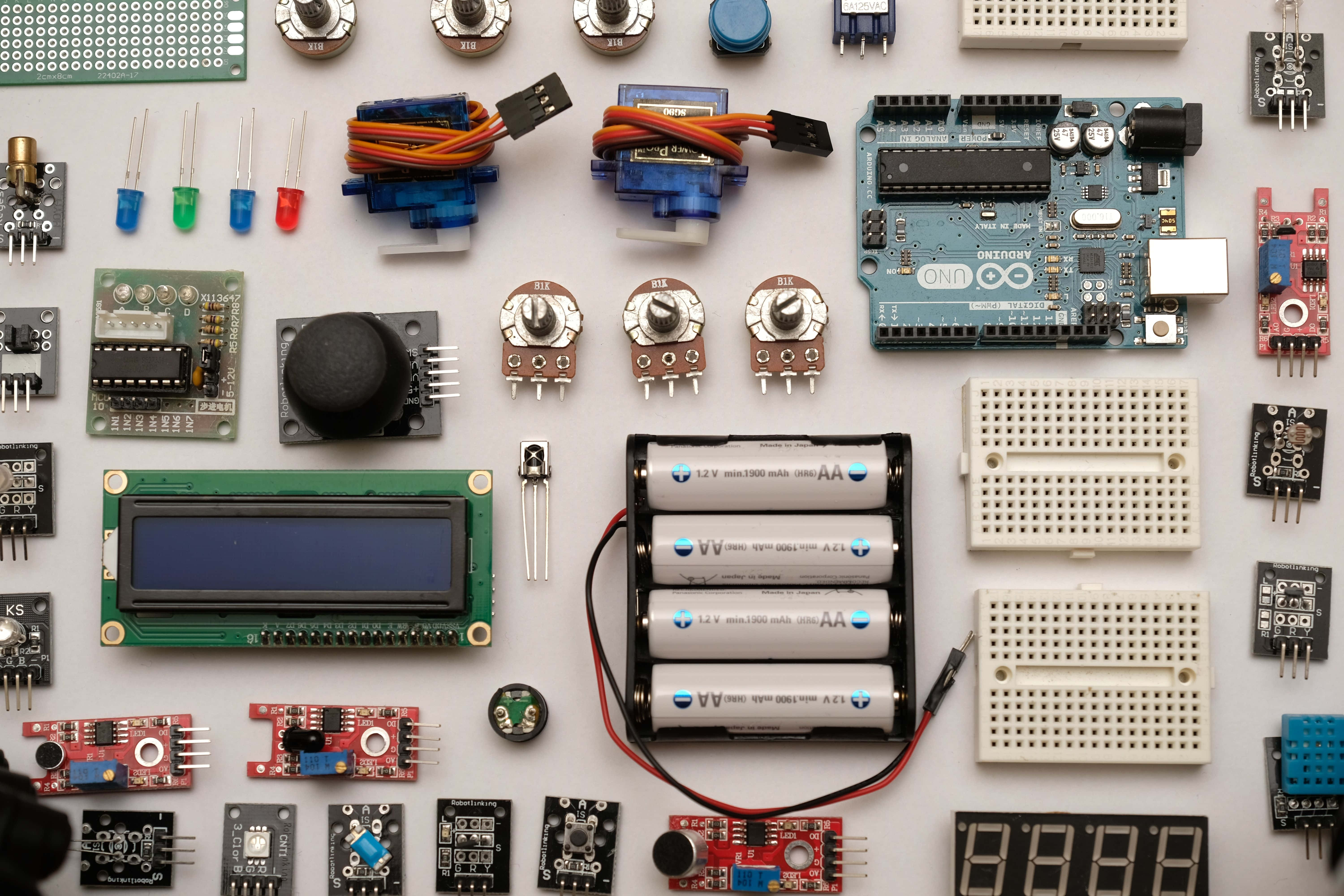 Electronic Components 桌布 壁紙 — 白色表面上整齊排列的各種電子元件和電路板的平鋪佈局。