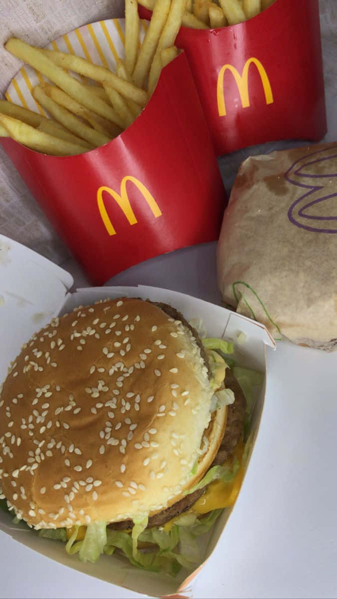 Mcdonalds Food 桌布 壁紙 — 白色表面上紅色盒子內芝麻麥當勞漢堡和薯條的特寫。