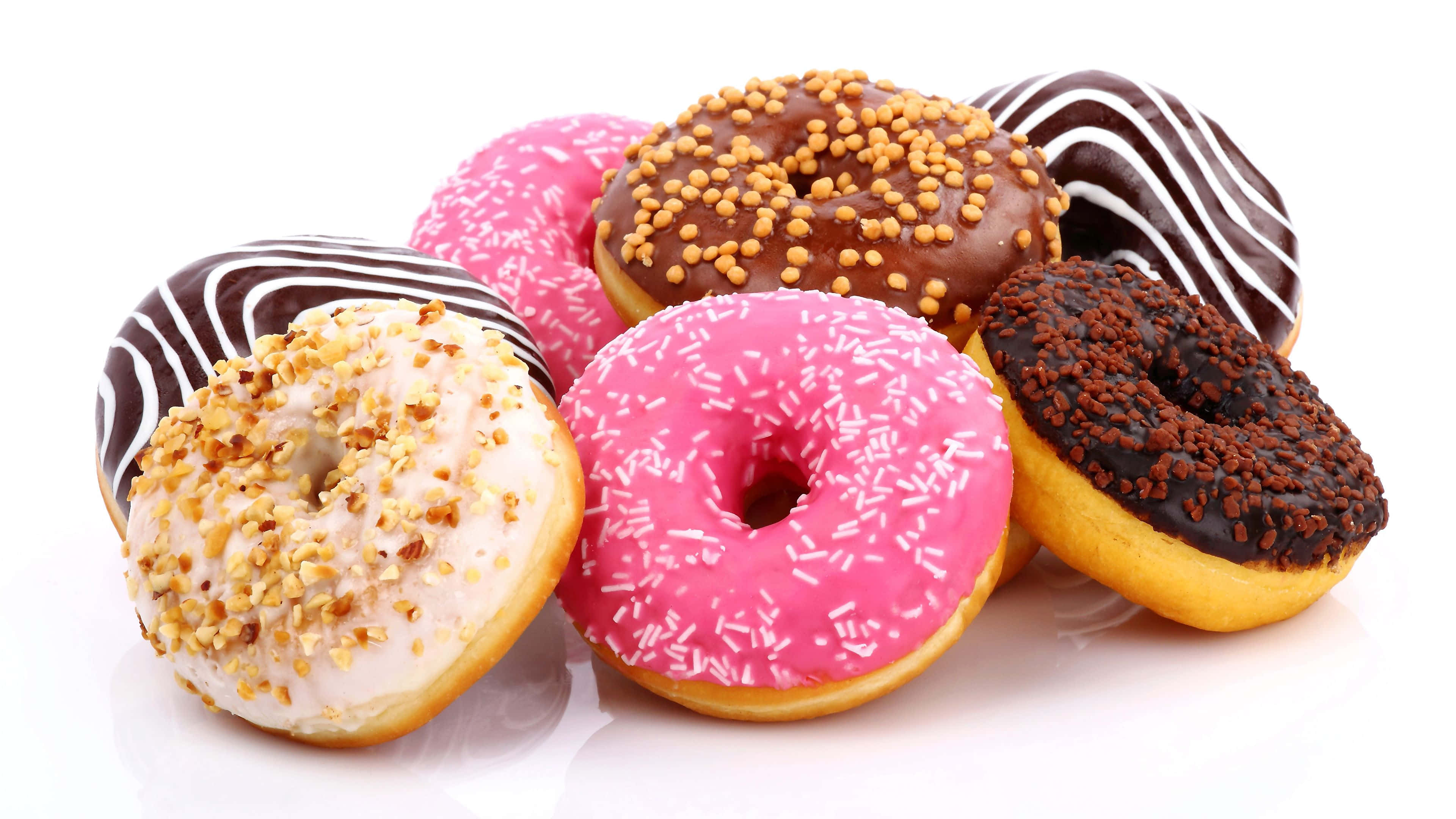 Dunkin Donuts 桌布 壁紙 — 白色表面上色彩繽紛的釉面裝飾甜甜圈，配有糖霜和巧克力淋醬。