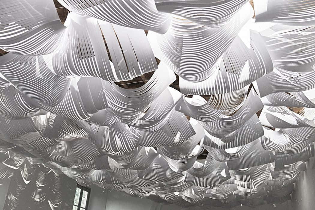 Installation Art 桌布 壁紙 — 白色褶皺紙條的天花板裝置營造出流動的雲狀天篷，帶有柔和陰影。