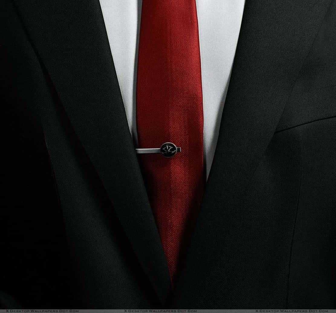 Red Tie 桌布 壁紙 — 白色襯衫背景下，黑色尖挺西裝搭配大膽紅色領帶和銀色領帶夾的特寫。