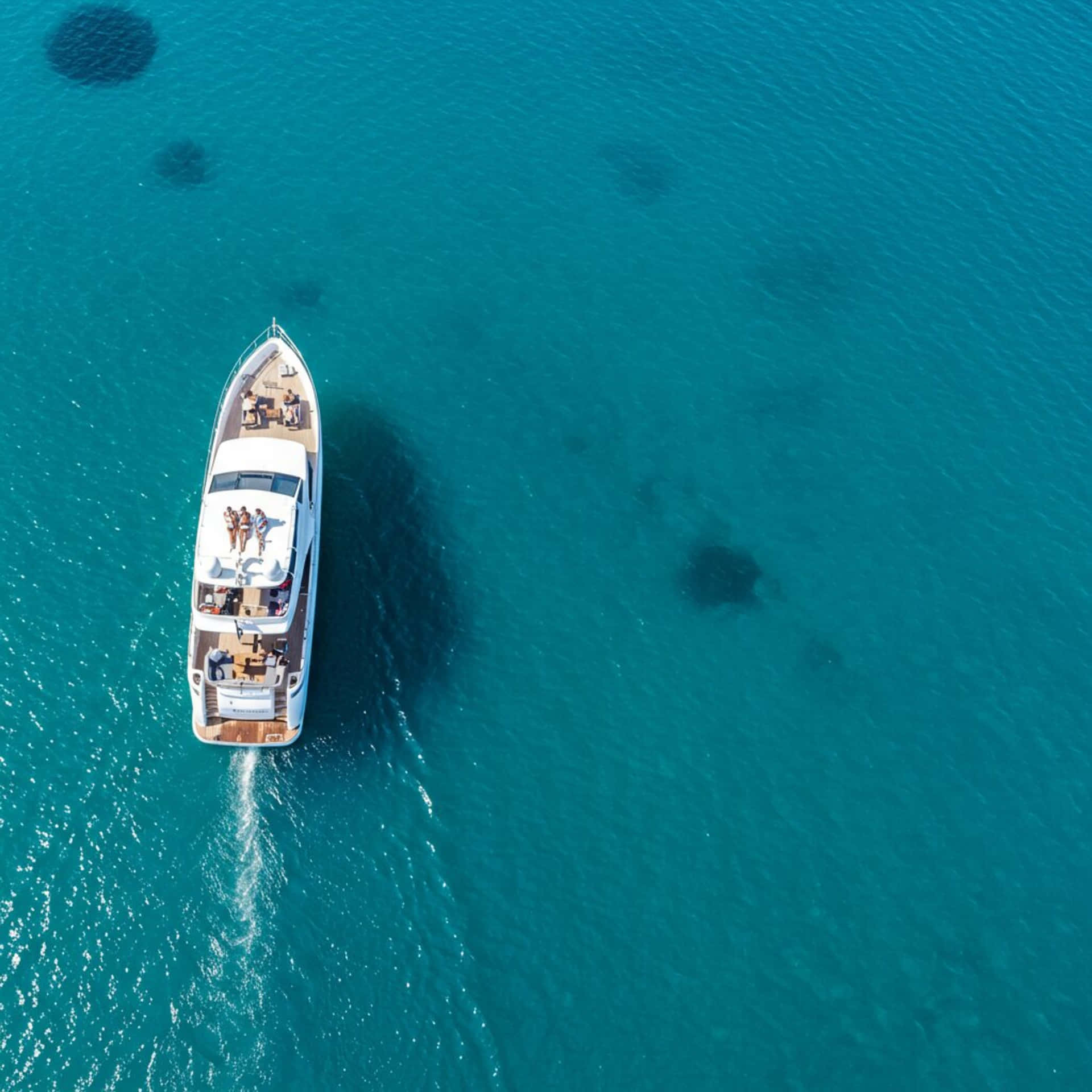 Yoth on the sea 壁紙 — 白色豪華遊艇在充滿活力的碧綠海水上巡航的鳥瞰圖，人們在甲板上放鬆。