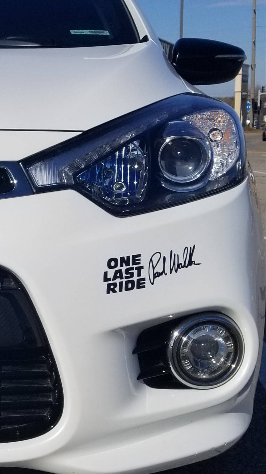 Paul Walker 桌布 壁紙 — 白色車前保險桿特寫，上面貼有黑色「ONE LAST RIDE」貼紙及保羅·沃克簽名。