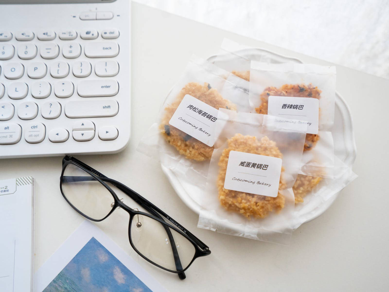 Pastries 桌布 壁紙 — 白色鍵盤眼鏡和包裝好的餅乾整齊地放在明亮的白色桌面上。
