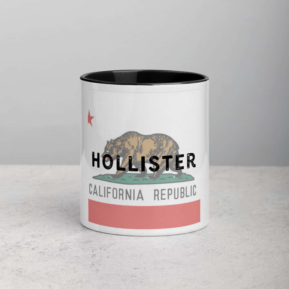 hollister 桌布 壁紙 — 白色陶瓷杯，黑色邊緣和內部，帶有復古加州共和國旗設計，印有「Hollister」文字和熊圖案。