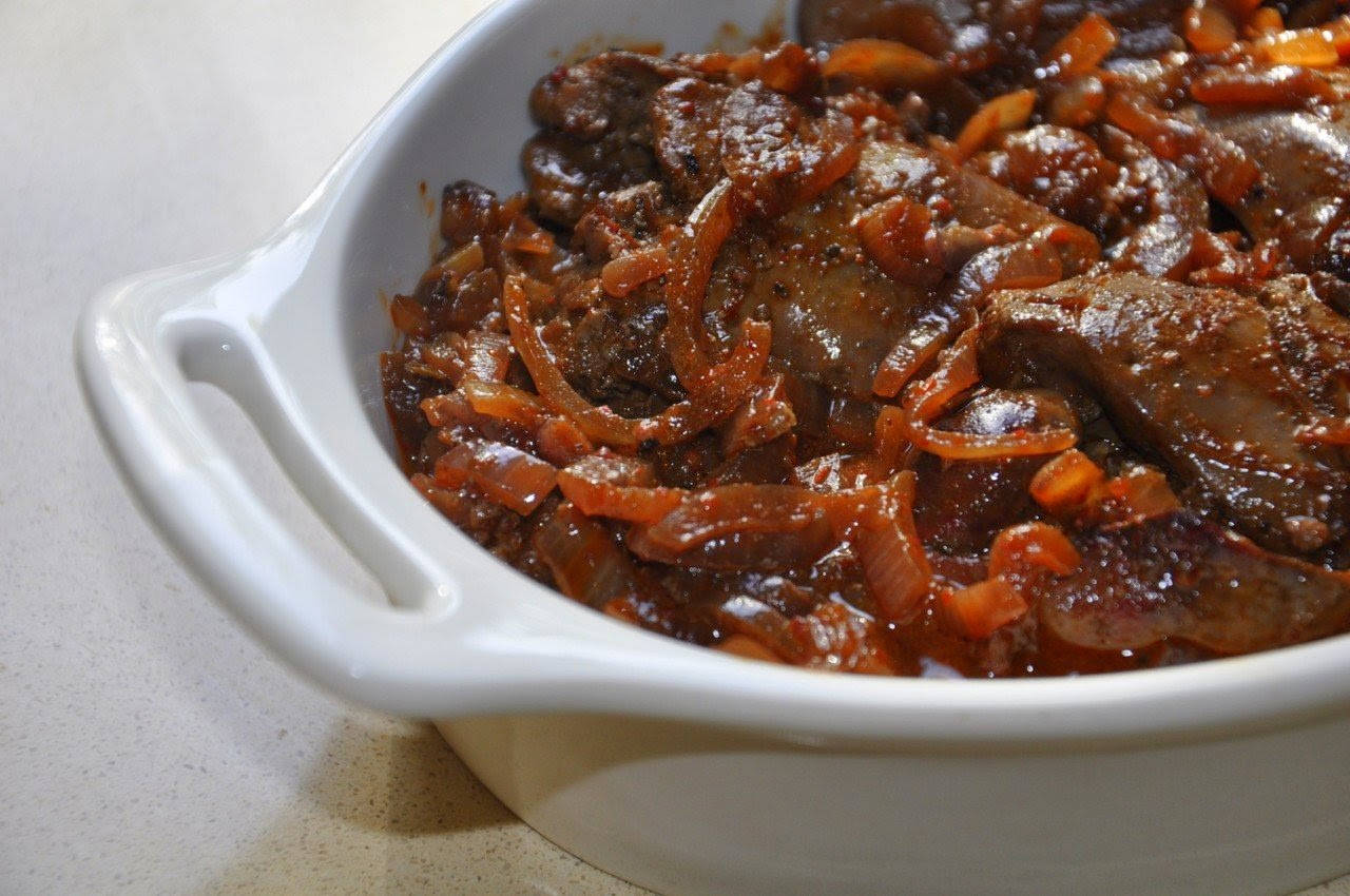 Onion 桌布 壁紙 — 白色陶瓷烤盤中濃郁的棕色燉肉和焦糖洋蔥的特寫。