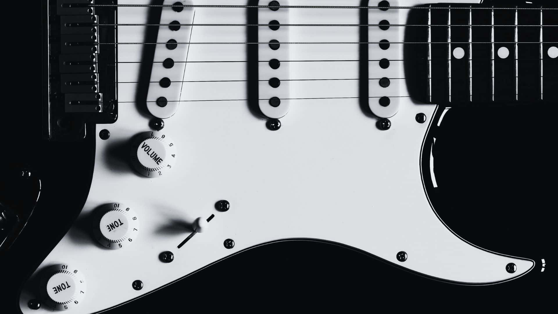 Black And White Guitar 桌布 壁紙 — 白色電吉他的控制旋鈕和琴弦在深色背景上的特寫。