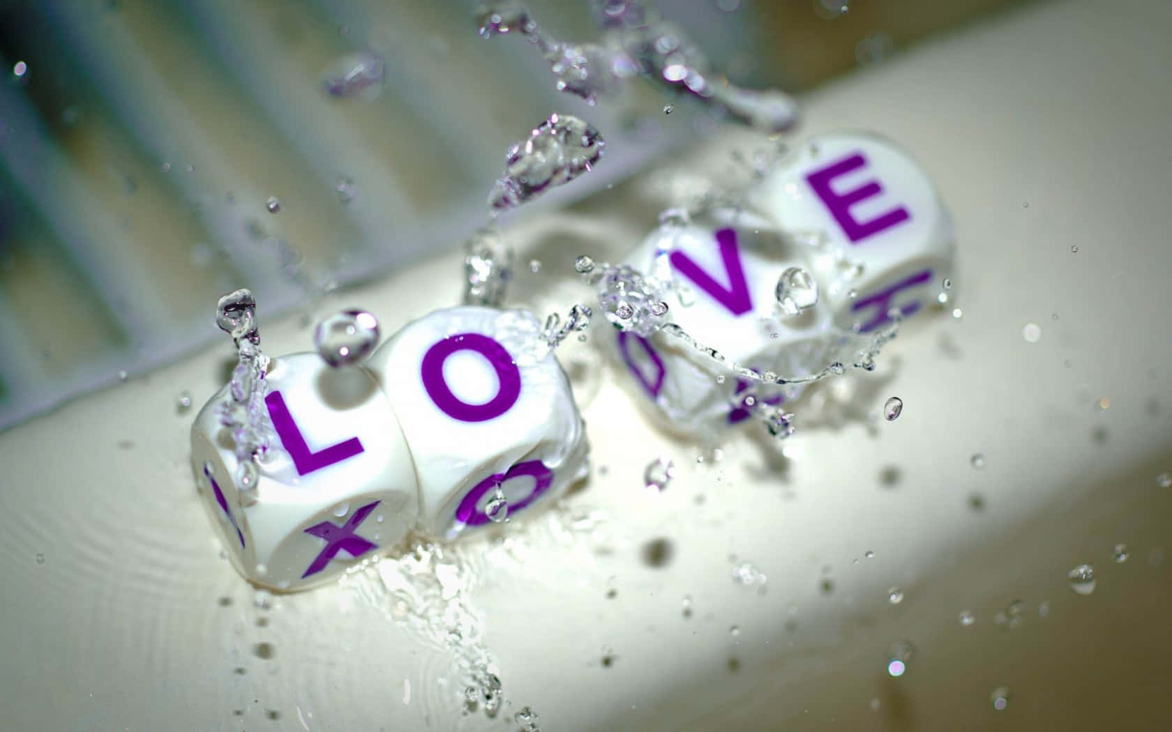 Beautiful Love 桌布 壁紙 — 白色骰子用紫色字母拼出love，在清澈的水中於淺色表面上戲劇性地飛濺。
