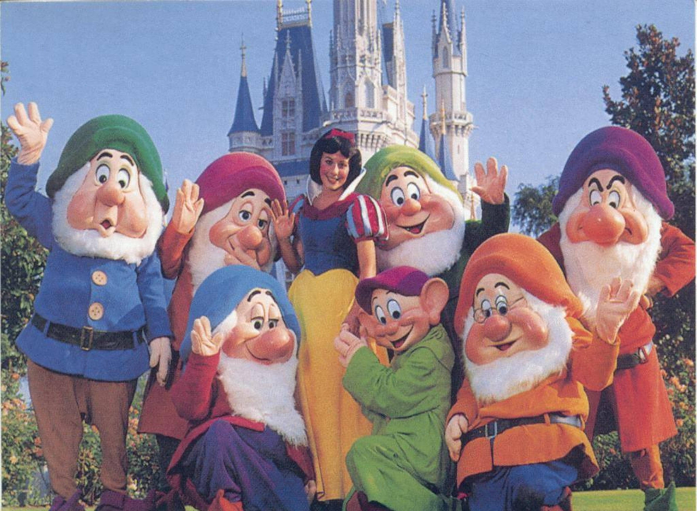 Seven Dwarfs 桌布 壁紙 — 白雪公主與七個小矮人在晴朗藍天下於城堡前開心地擺姿勢。