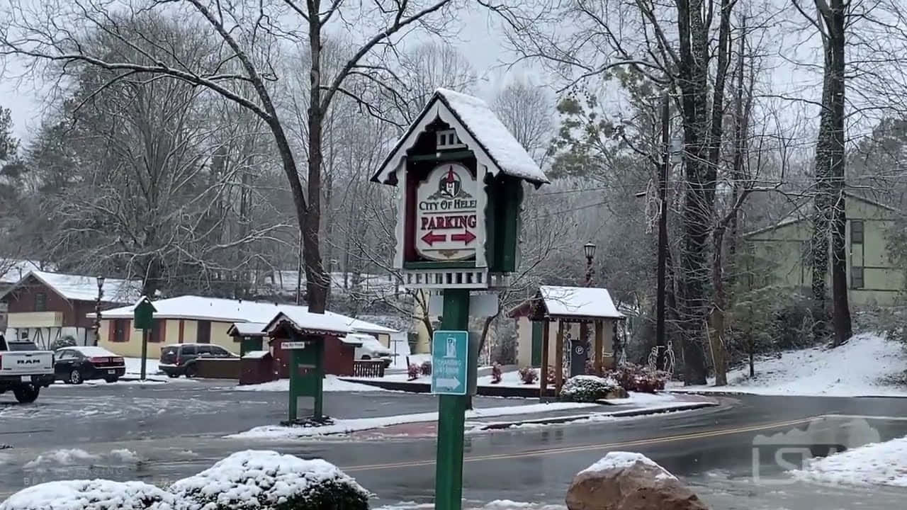 冬天 桌布 壁紙 — 白雪覆蓋寧靜的城鎮街道，光禿的樹木和一個復古停車標誌高高矗立在前景中。