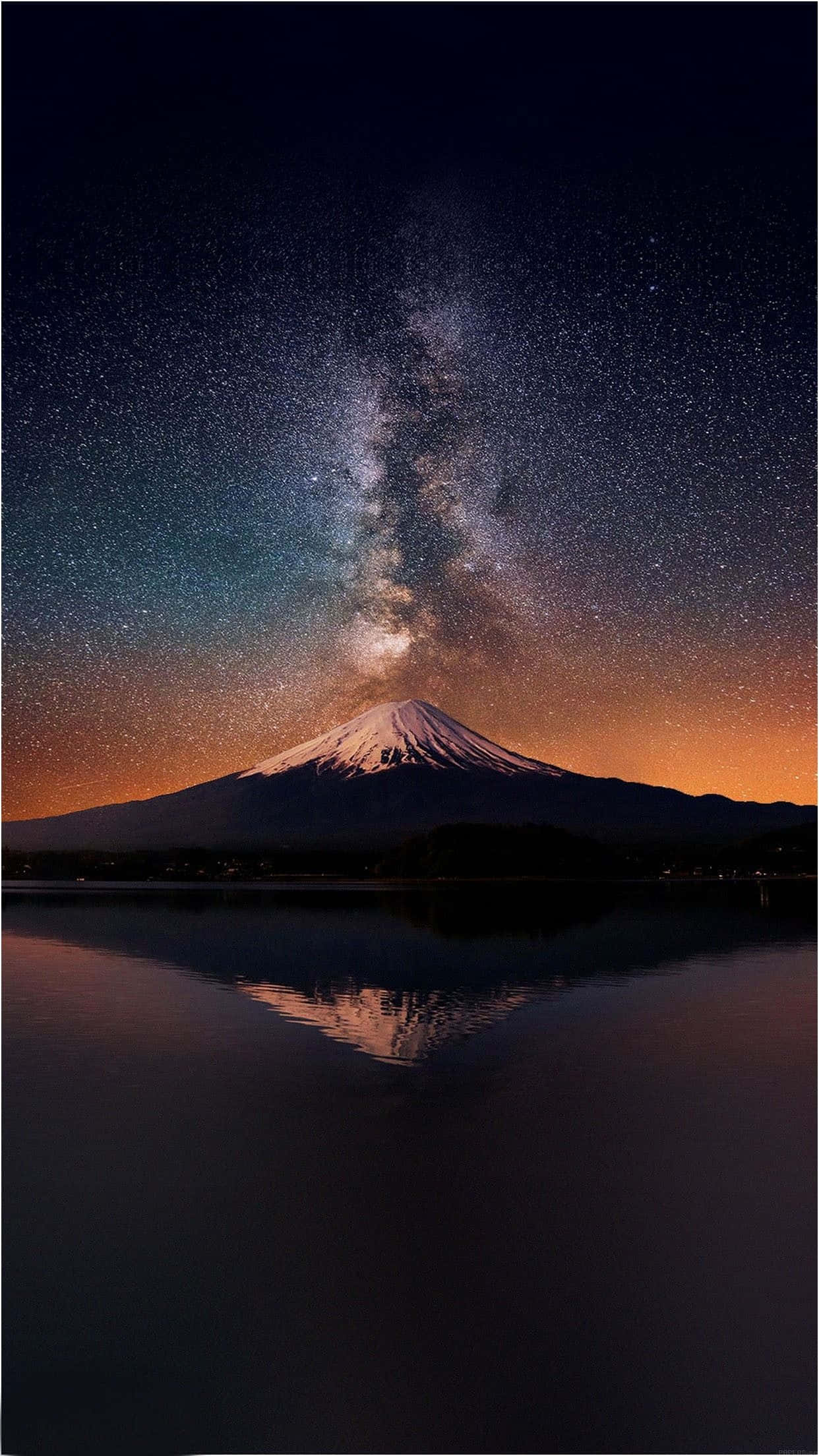 桌布 壁紙 — 白雪覆蓋的富士山在平靜的水面上完美倒映，上方是銀河拱橋的璀璨星空。